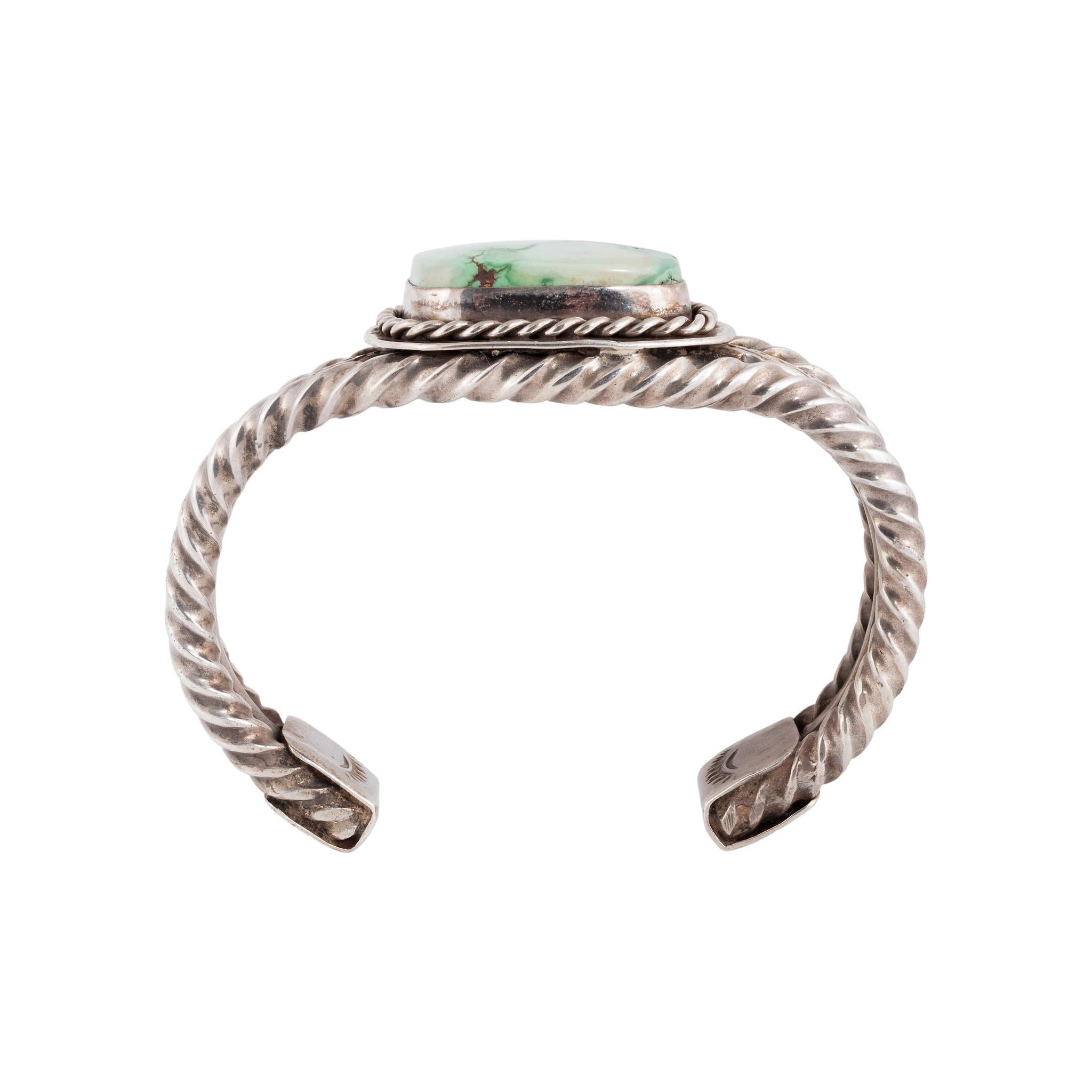 Bracelet manchette en argent et turquoise verte du lac Carico de Navajo. Manchette à trois bandes avec corde torsadée et bandes estampées. La pierre est d'un vert très clair avec une matrice vert foncé dans un coin. Elle est taillée en rectangle et