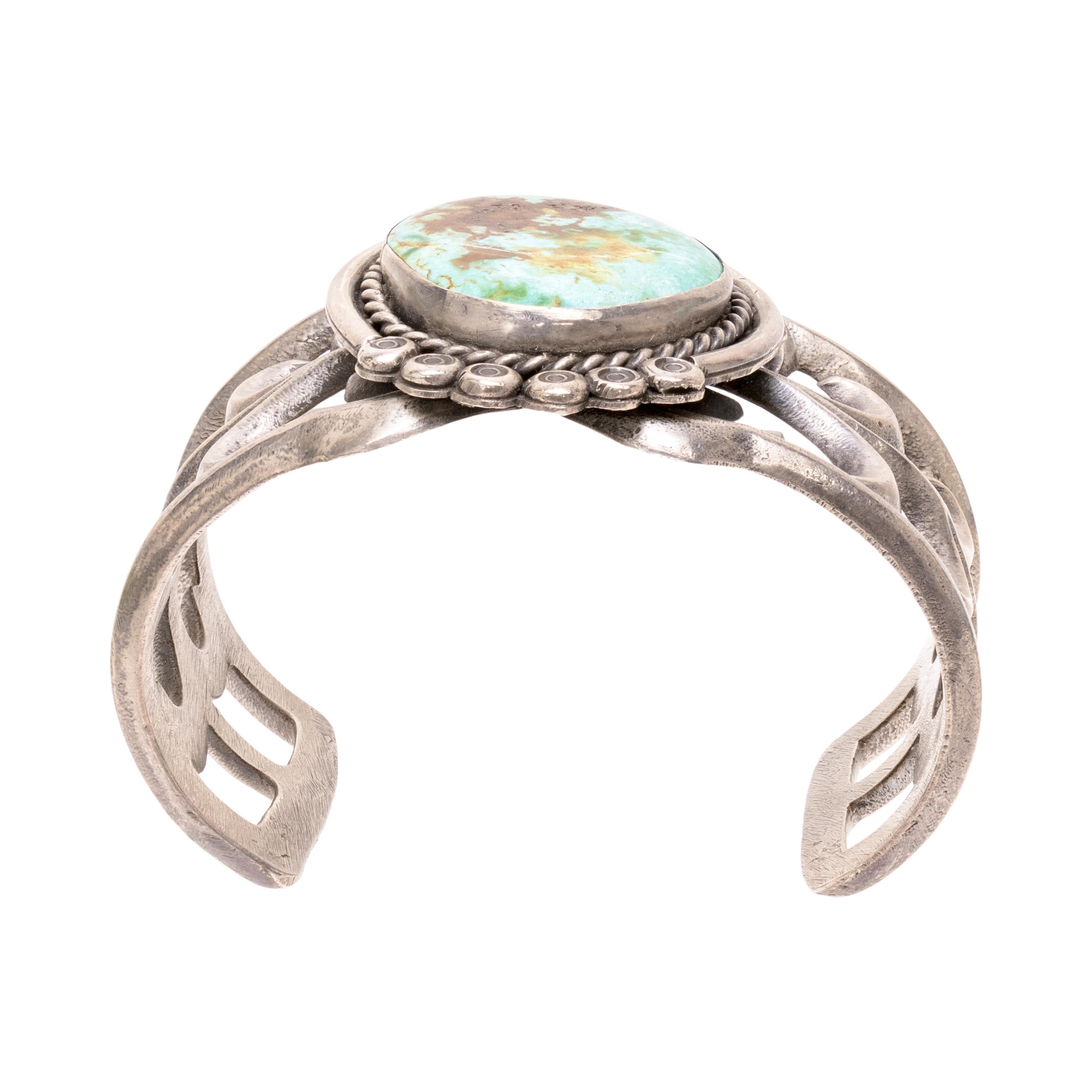 Bracciale Navajo in turchese a pietra singola su bracciale in argento massiccio. La pietra turchese Carlin è di un brillante blu acqua con una bellissima matrice stratificata di marrone, oro, verde e bianco. La pietra è incastonata in un castone con