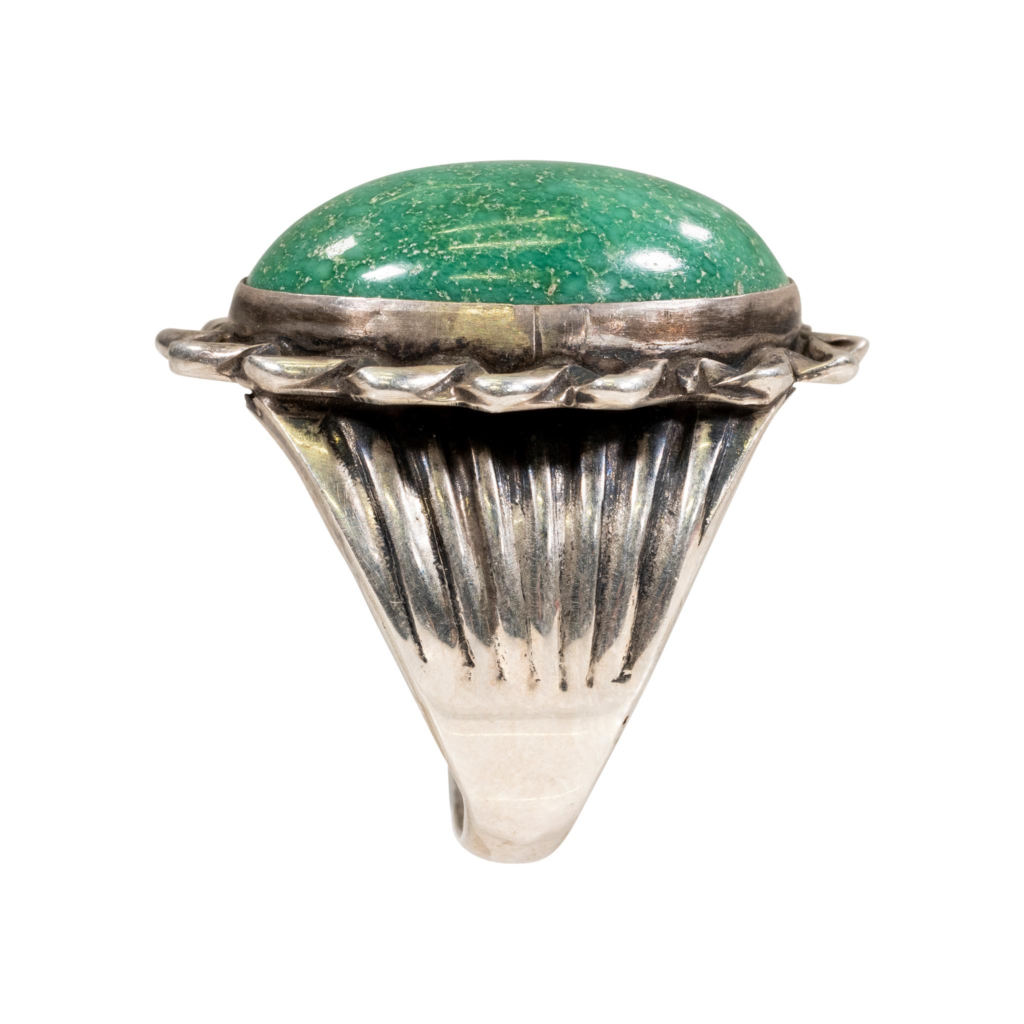Beautiful greenish Cerrillos Mine turquoise ring on sterling silver with detail surrounding center stone and engraved swipes on sides of band.

PERIOD: After 1950
ORIGIN: New Mexico
SIZE: Size 11 Stone 3/4