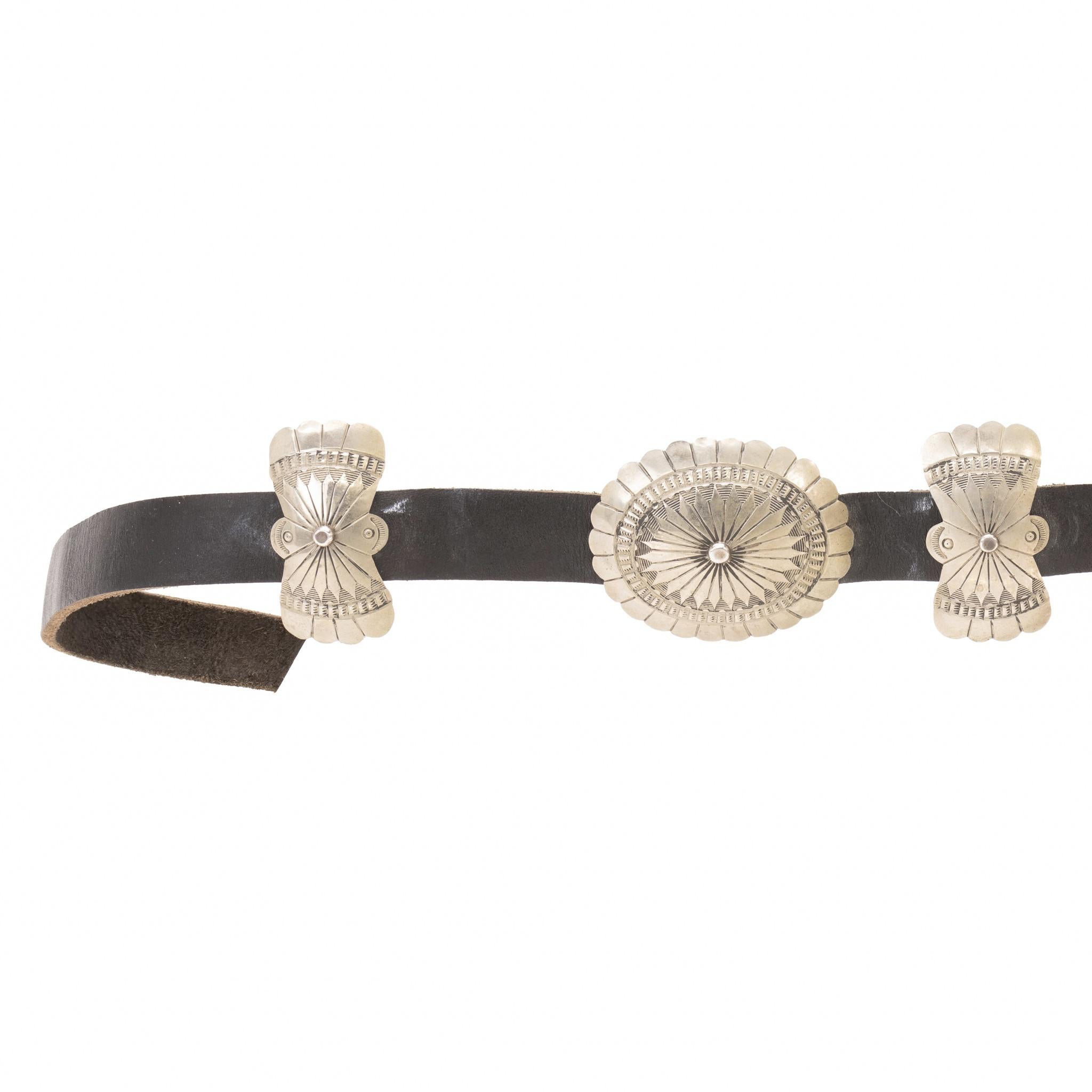 Navajo coin silver concho belt. Total of twelve alternating butterfly and oval conchos with matching rectangular buckle. Each concho having hand-stamped traditional designs. Nice patina to silver that could be polished out if desired. Conchos having