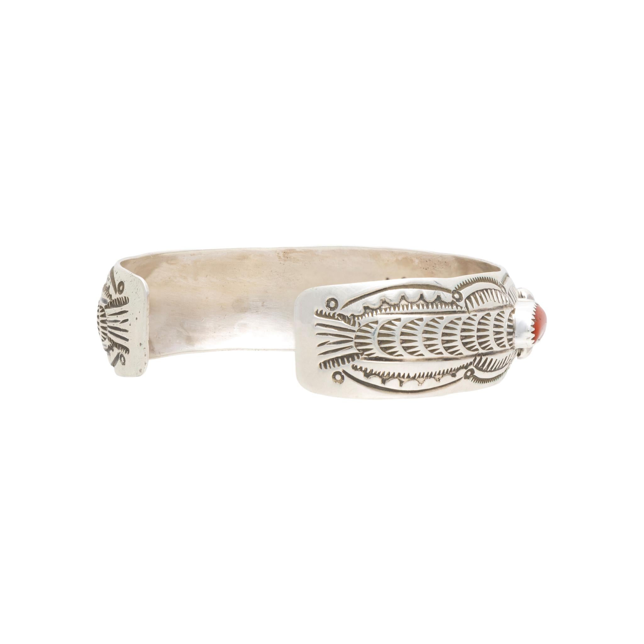 Bracciale in corallo Navajo e argento sterling. Pietre di corallo di qualità A incastonate in un castone a dente di sega, sollevate sopra disegni di palmette stampati a mano su una fascia di sterlina a filo con decorazioni di perline di sterlina.