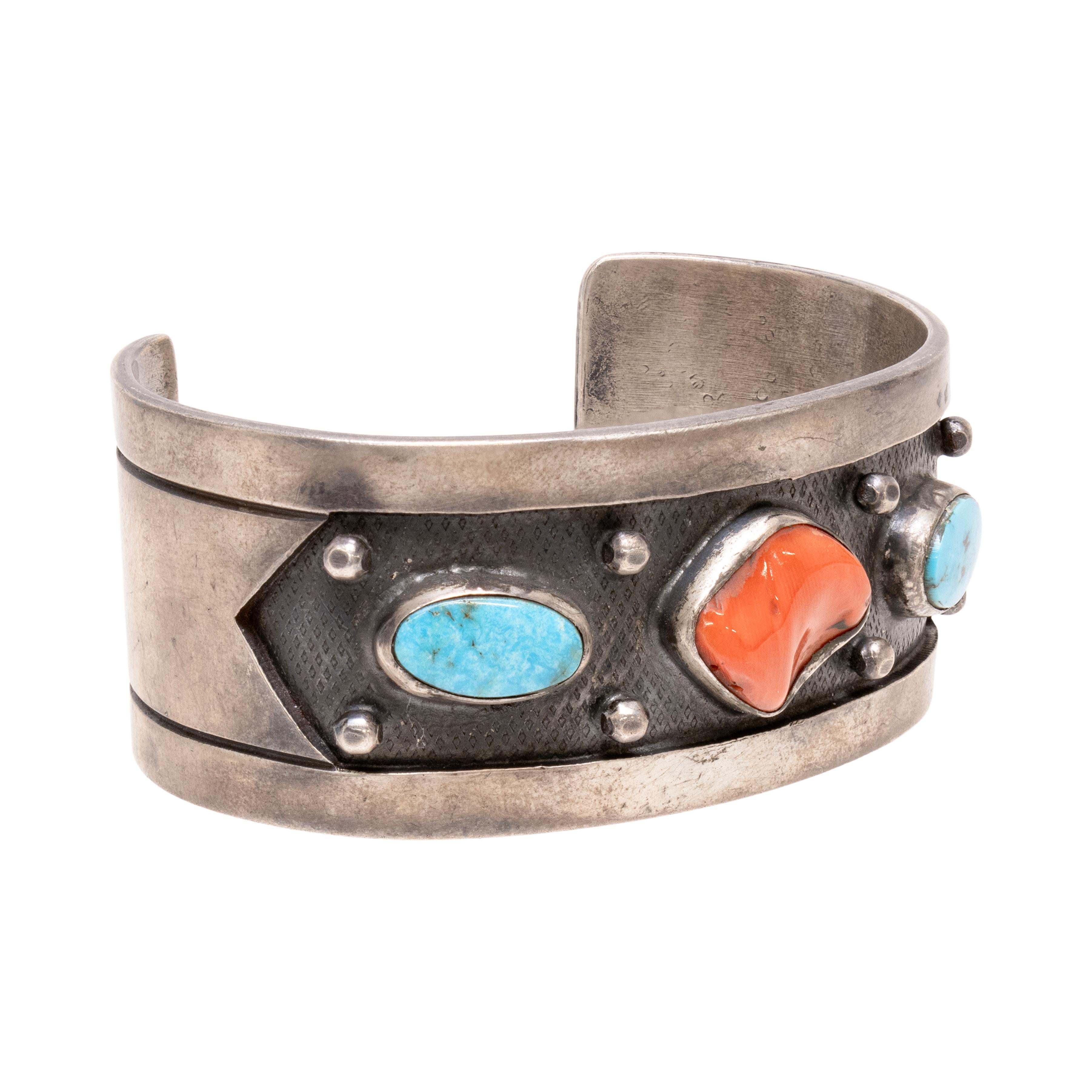Pulsera brazalete navajo con tachuelas de coral y turquesa. Dos piedras de turquesa con una pepita de coral engastada en el centro. La turquesa procede de la mina Cerrillos de Nuevo México. La turquesa es de un azul brillante excepcional, la piedra