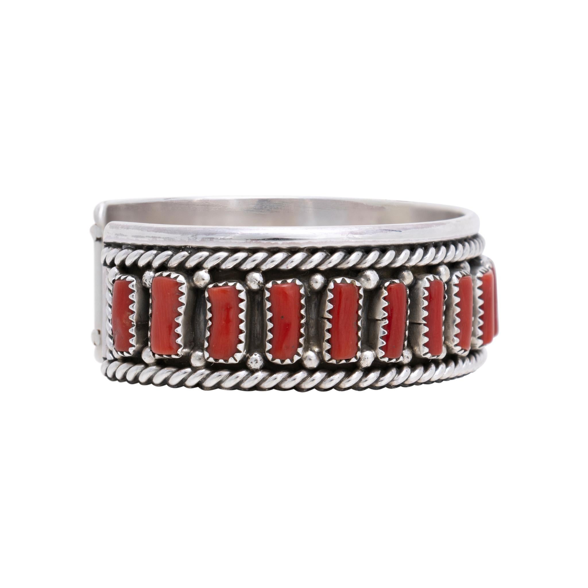 Bracelet manchette en corail indien Navajo et argent sterling par Chester Charley. Magnifique bracelet composé de 21 pierres de corail de première qualité serties dans une boîte d'ombre avec une corde torsadée et une bordure de perles en argent. Les