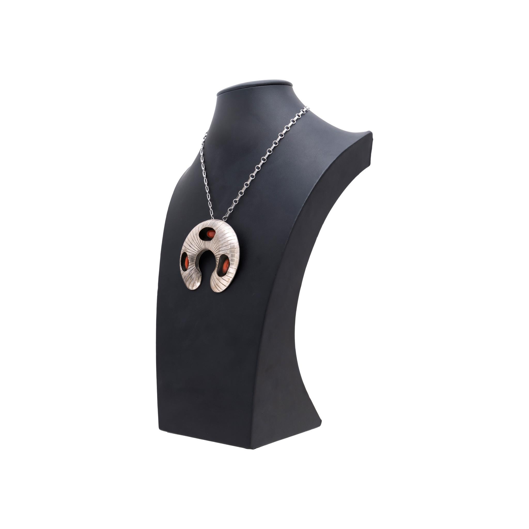 Navajo coral and sterling silver necklace with raised shadow box sterling silver naja holding three coral stones set inside. Pendant attached to link chain with traditional clasp. No maker's mark. Old Pawn. From the Indian Store in Clovis, New