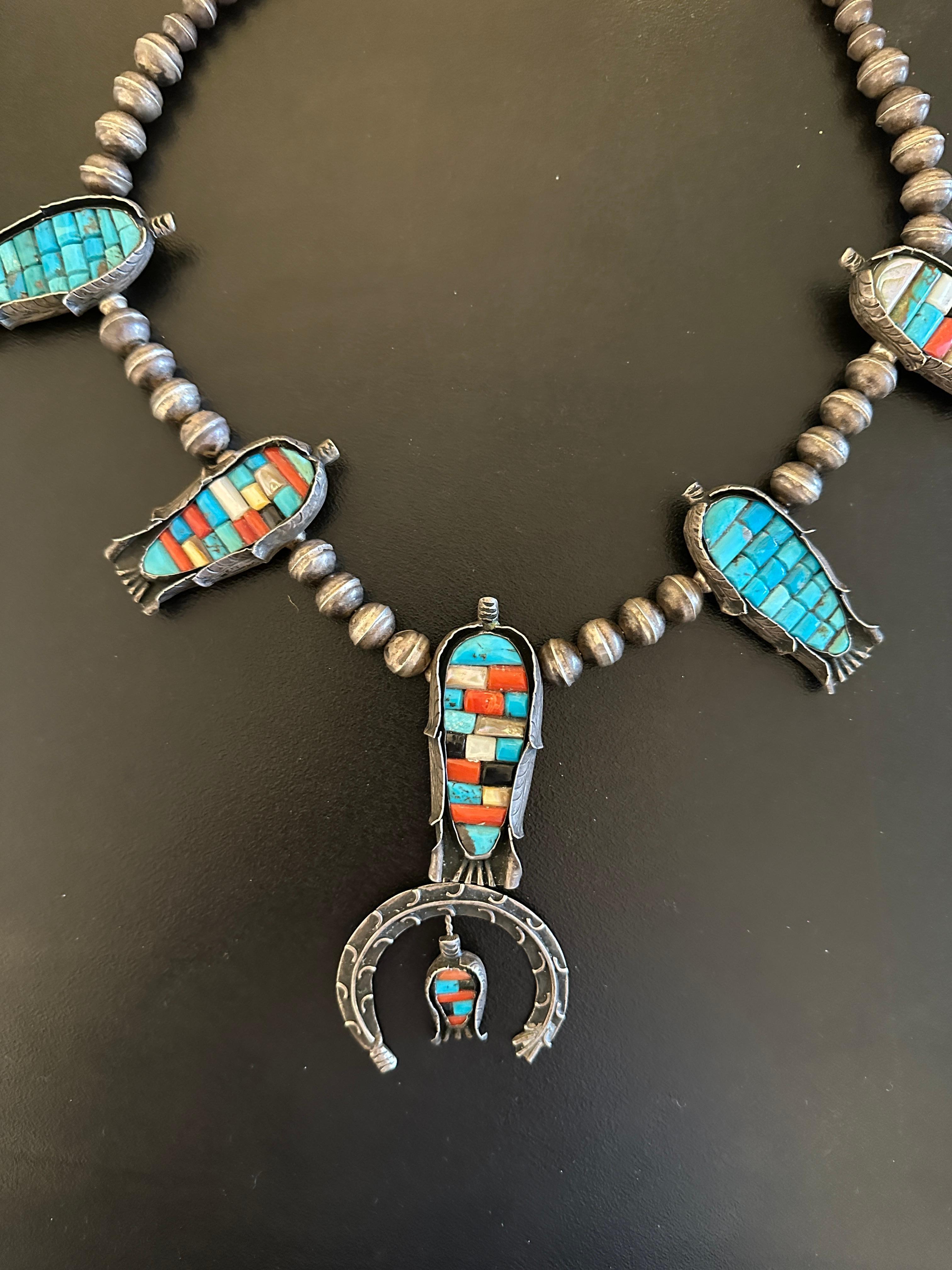 THIS IS A MAGNIFICENT ANTIQUE NAVAJO NATIVE AMERICAN INDIAN CORN MOTIF SQUASH BLOSSOM NECKLACE WITH TURQUOISE, CORAL, BLACK ONYX AND MOTHER OF PEARL, DATING TO CIRCA 1930.  THE NECKLACE IS A MUSEUM QUALITY PIECE AND IS EXTREMELY RARE. 
THE EARLY