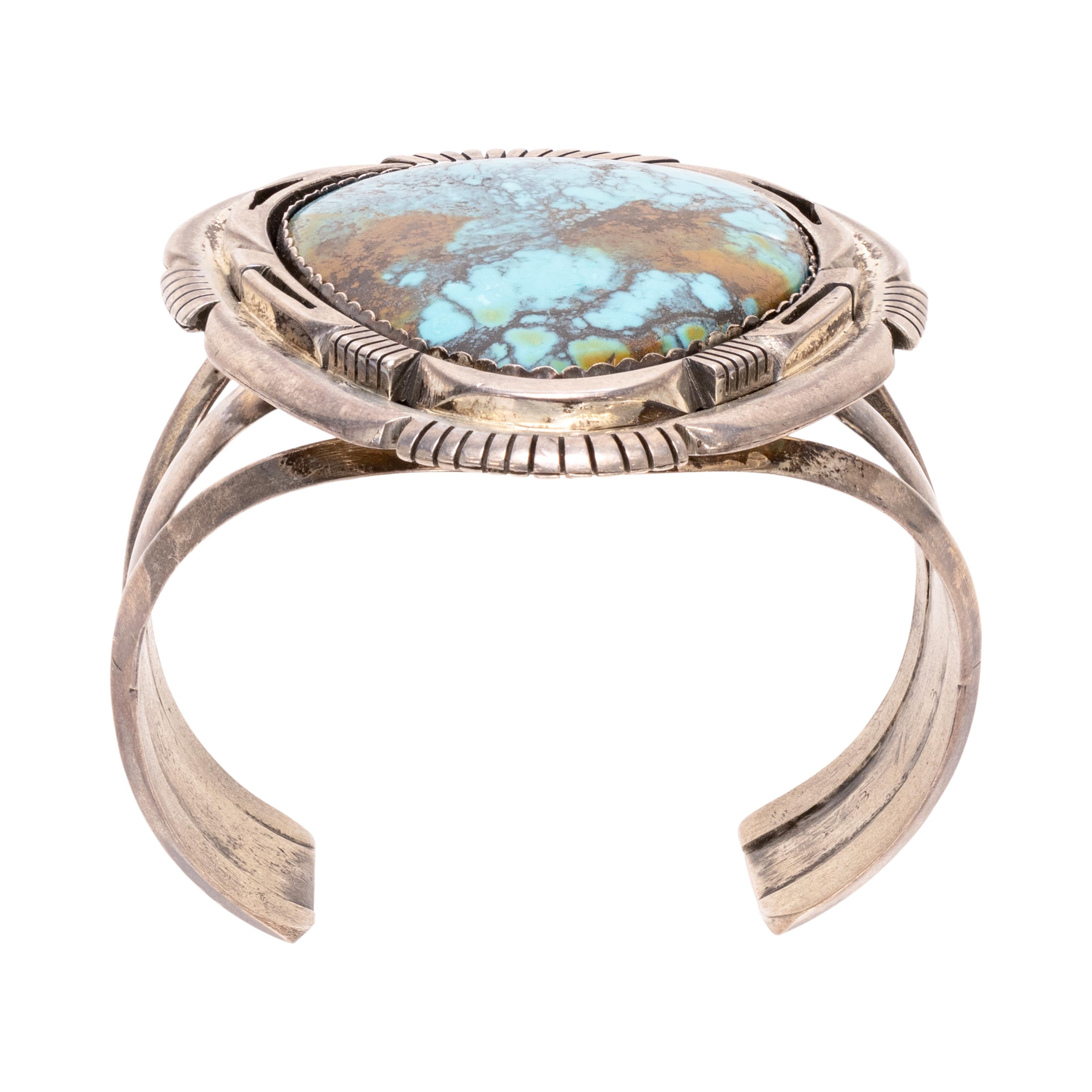 Navajo single stone bracelet. The Turquoise is from the Damele Mine in Nevada. Large beautiful stone, slash work on sterling bracelet with nice patina (can be buffed out to make shiny again).  Maker's mark 