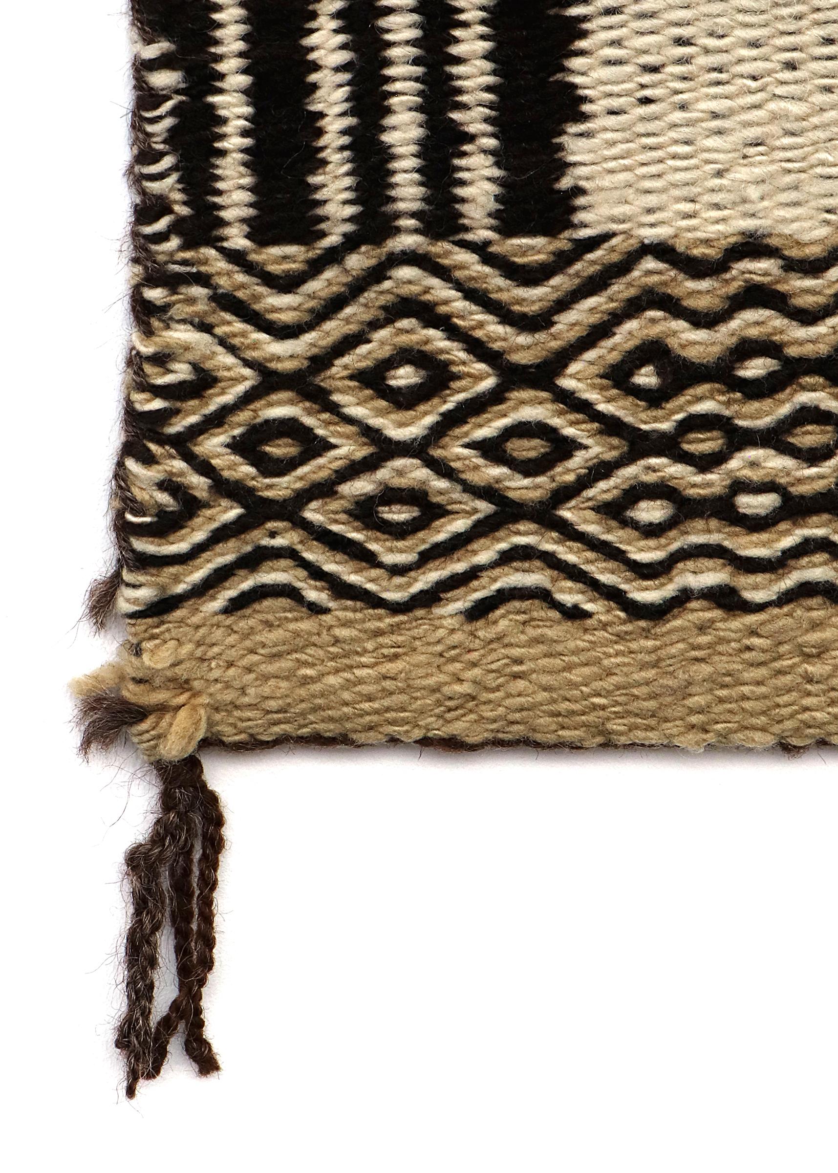 This circa 1930s Navajo double saddle blanket is a striking example of early 20th-century Native American weaving. Handwoven in double-faced twill, the blanket features handspun wool in natural fleece tones of brown, black, and ivory, showcasing an