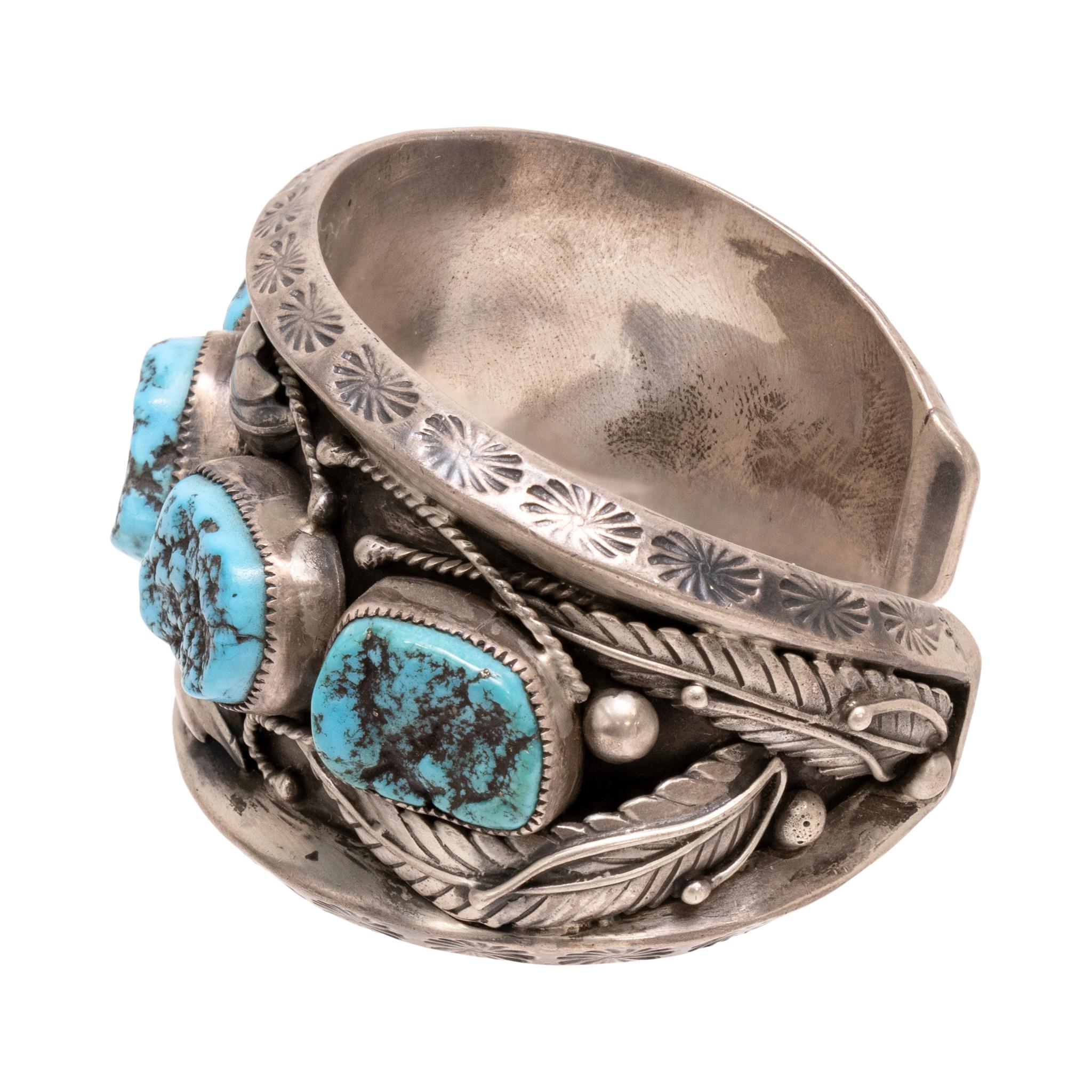 Navajo five nugget bracelet. Signed LB with thunderbird or eagle hallmark. Stones are surrounded by feather, leaf, and silver scrolled details. Cuff is thick and study. The turquoise is from the Kingman Mine in Arizona. Marked Sterling. Solid piece,