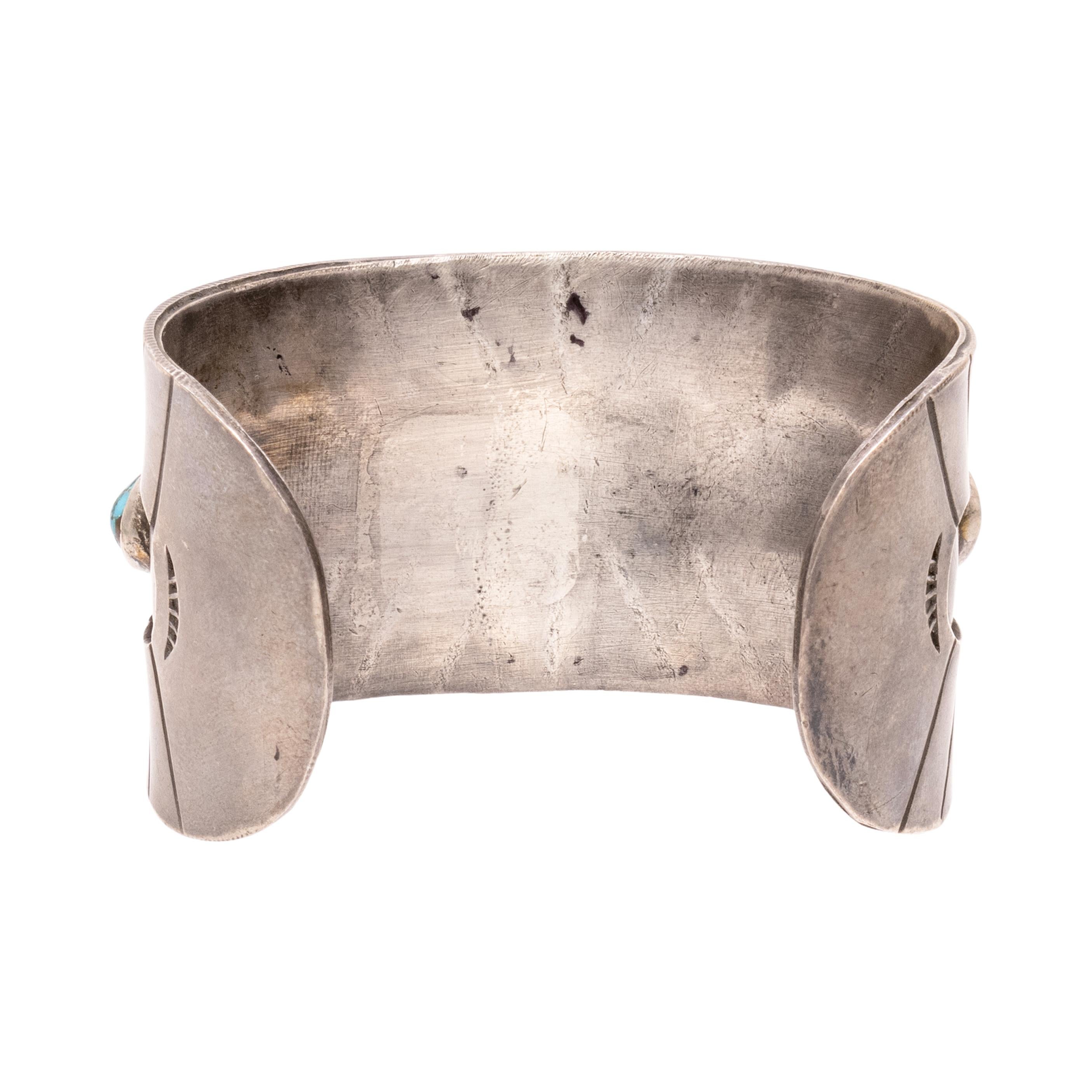 Bracelet Navajo à cinq turquoises. Vieux pion. Les pierres sont serties en ombres chinoises sur une épaisse manchette en sterling hachurée. Les pierres ont une belle matrice brune et blanche et la pierre centrale présente de superbes toiles