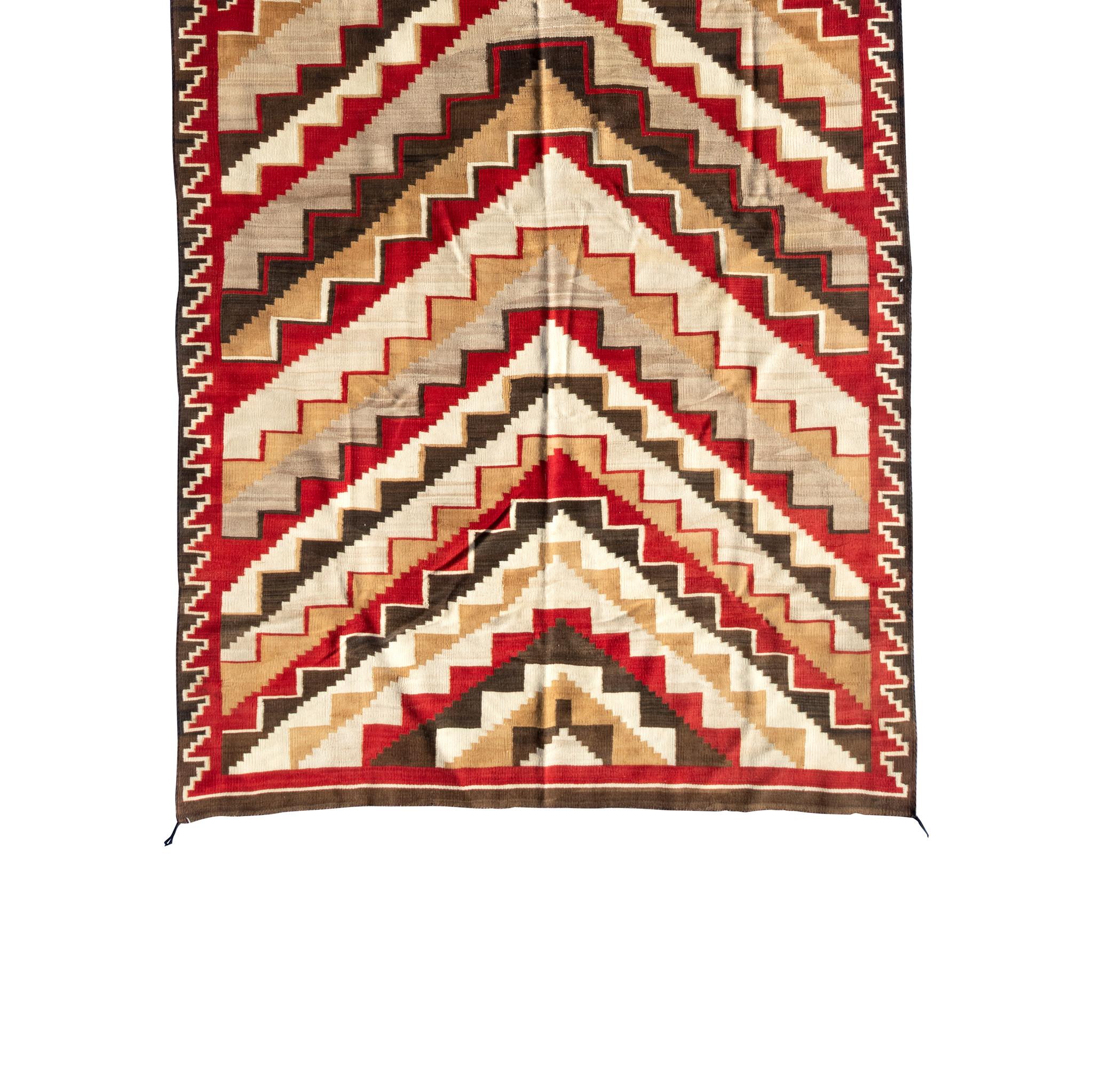 Grand tissage Navajo Ganado. Il présente de superbes motifs géométriques et des couleurs vives (rouge, marron, crème et jaune). Grande pièce qui ferait un excellent tapis de sol ou une suspension murale. Début du 20e siècle. 7'9 