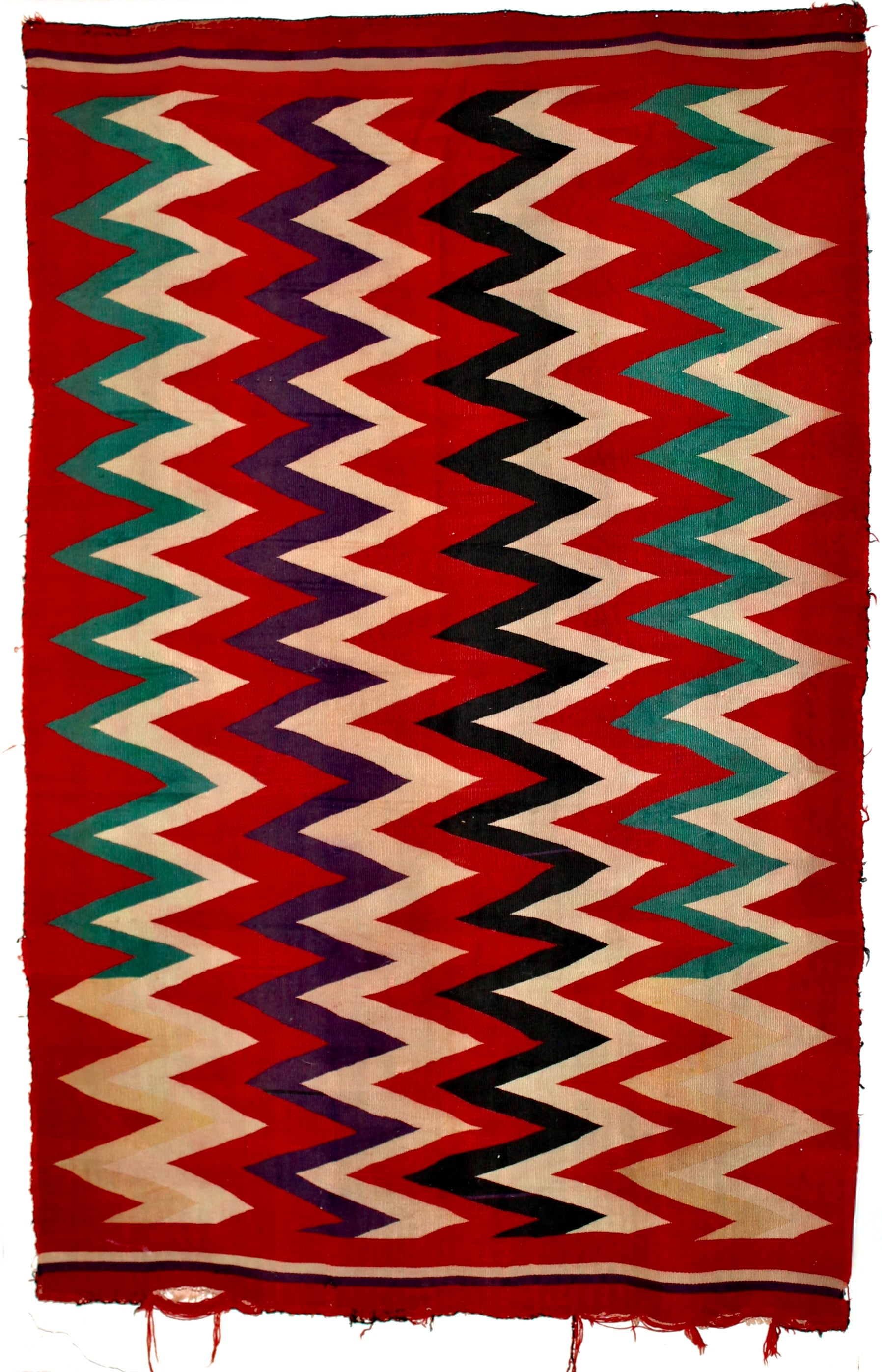Un Whiting (fin du 19e siècle) composé de lignes étroites verticales en zig-zag de couleur verte, blanche, violette et noire, sur un fond rouge foncé. 72x48