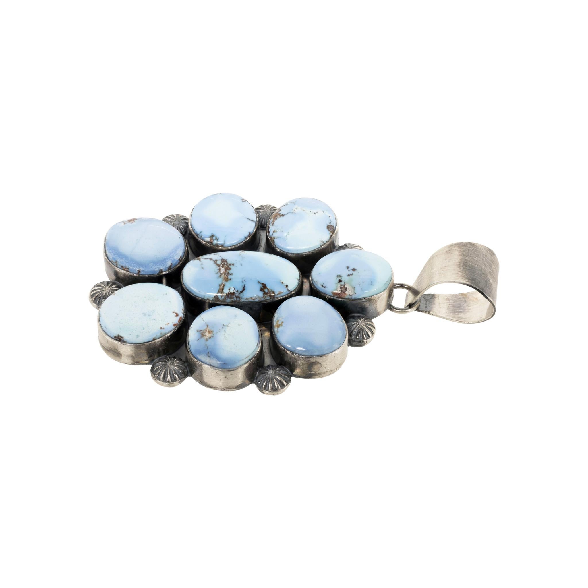 Pendentif en argent sterling et turquoise Navajo Golden Hill, réalisé par l'orfèvre Navajo Mary Ann Spencer. Huit pierres de qualité A avec de belles variations de couleur serties dans un motif floral avec des palmettes sur un fond en argent