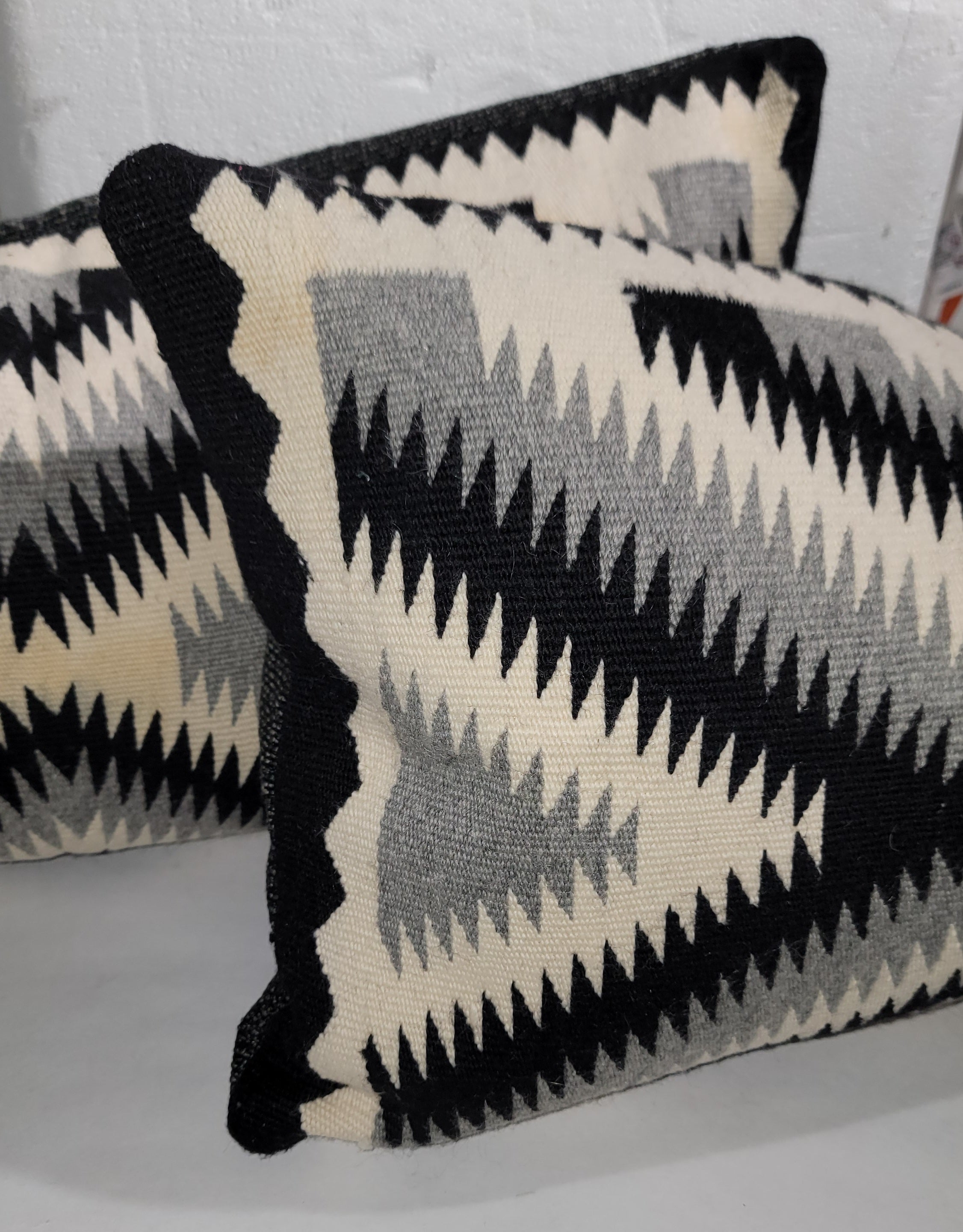 Questi straordinari cuscini bolsters in tessuto indiano Navajo con occhio abbagliante sono in ottime condizioni e sono in nero, crema e grigio.  Gli inserti sono in piuma e piumette, mentre il retro è in lino nero/grigio.
Questi cuscini bolster