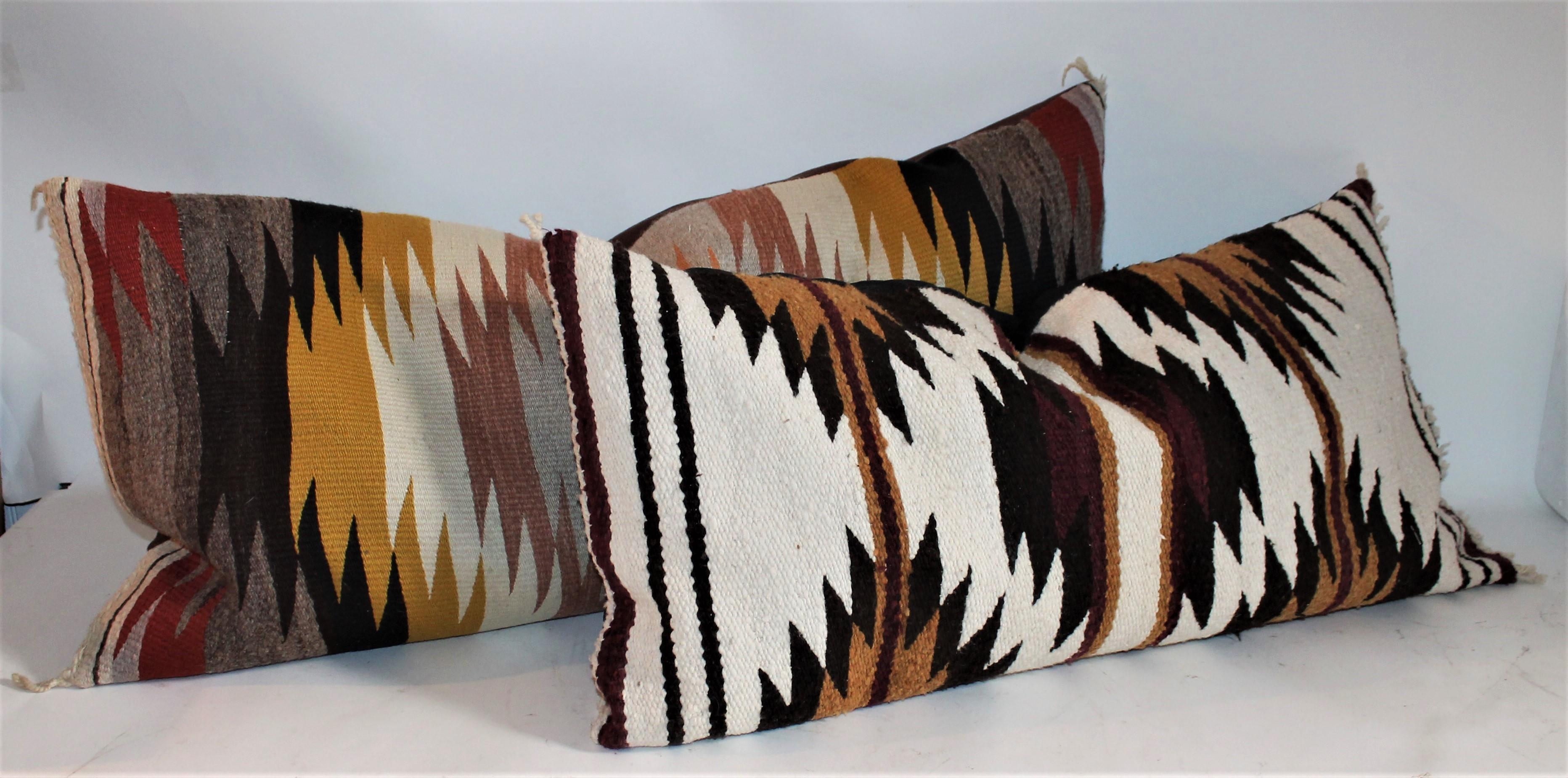 Navajo Indian weaving bolster pillows in fine condition. These were originally saddle blanket weaving's. The backing is in cotton black and brown linen. The inserts are down and feather fill.

Measures: 33 x 17 - Smaller pillow 
37 x 18 - Larger