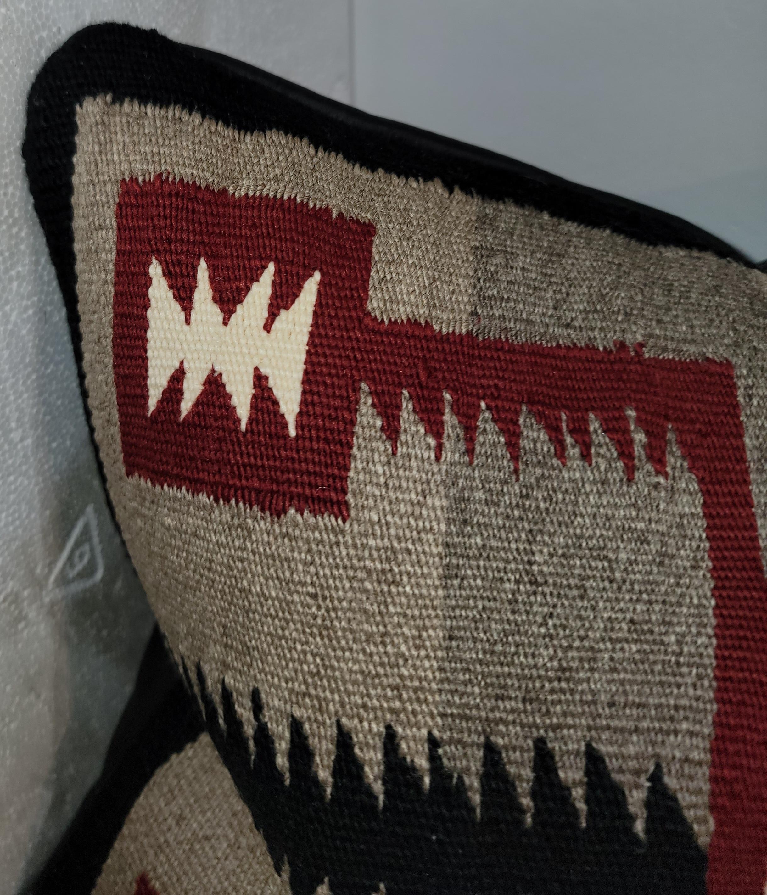 Questo raffinato cuscino bolster geometrico tessuto a mano dagli indiani Navajo è in ottime condizioni. Il supporto è in pelle nera italiana e l'inserto è in piuma e piumetta.