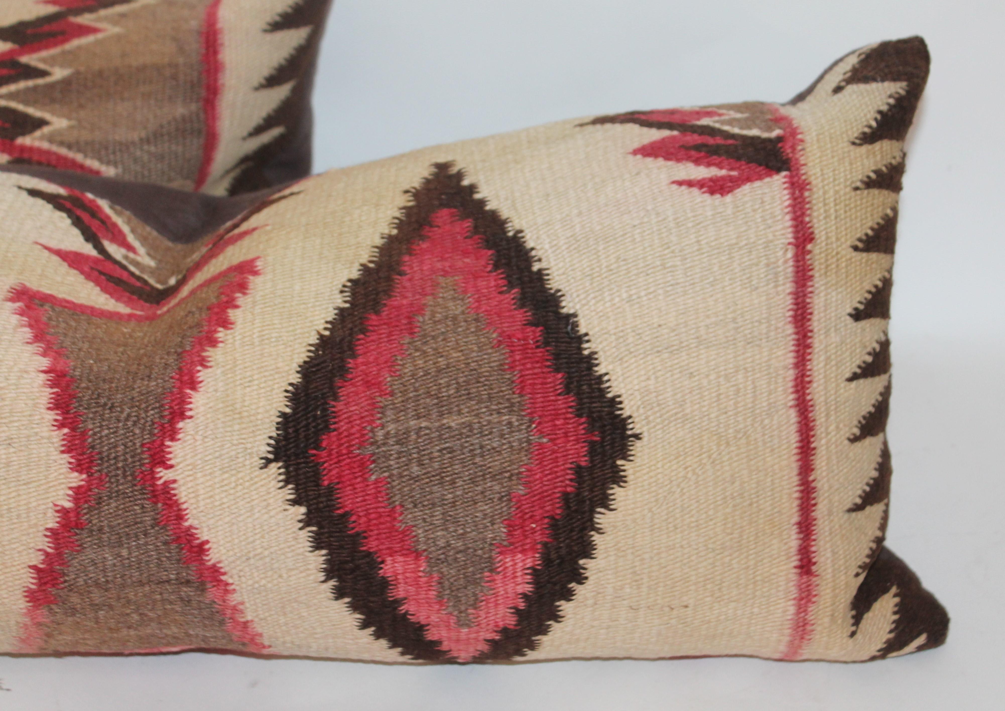 These two Navajo Indian saddle blanket weaving pillows are in good condition. The burg. And brown colors are most unusual. The condition is very good with a brown cotton linen backing. Sold as two.
