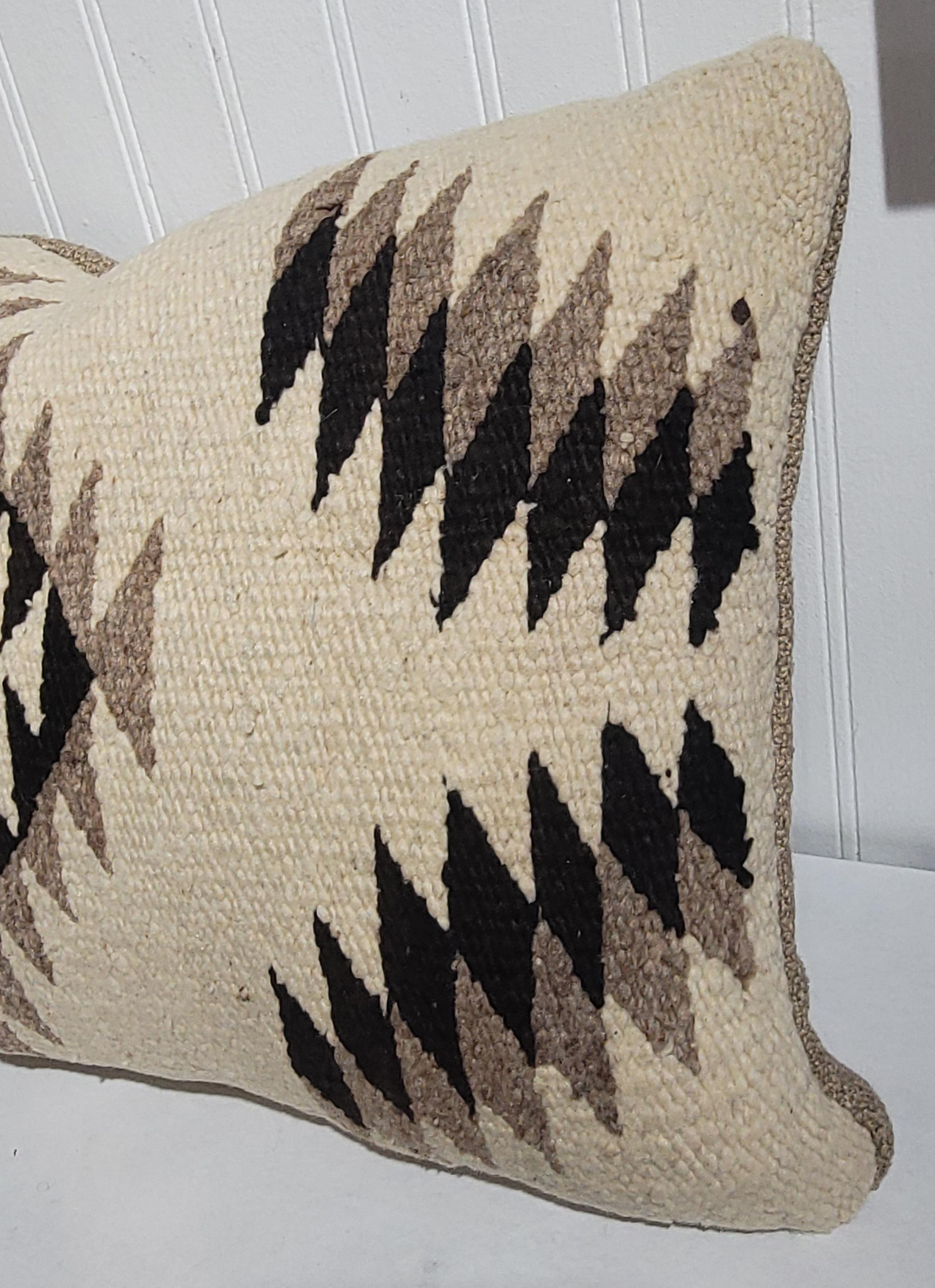 Fino cojín de tejido indio navajo con reverso de fina piel de oveja de color topo.Este deslumbrante ojo es de color topo/negro/marrón y fondo crema.