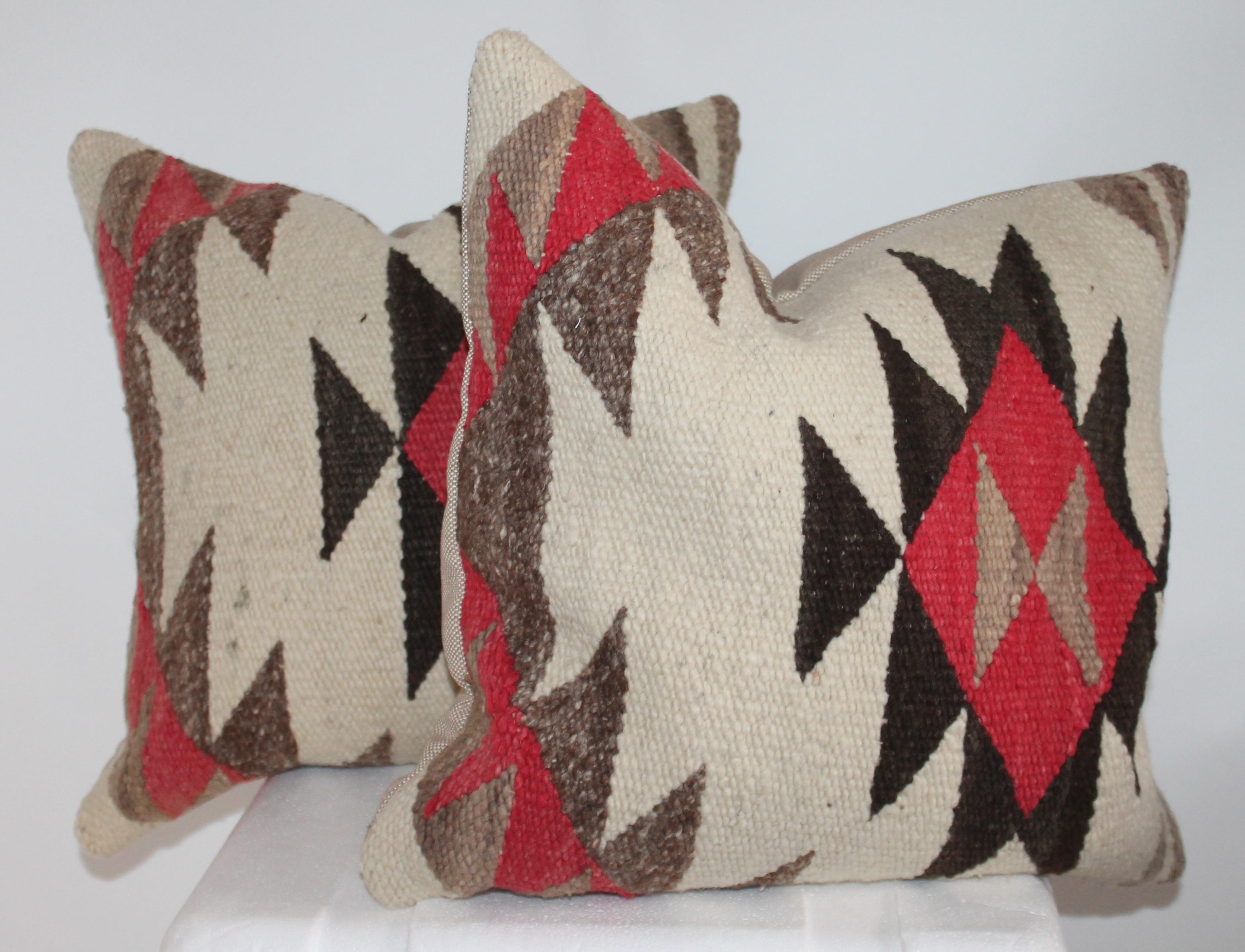 These geometric Navajo Indian weaving pillows are in fine condition. Sold as a pair. The backing is in a natural linen and inserts are down and feather fill.