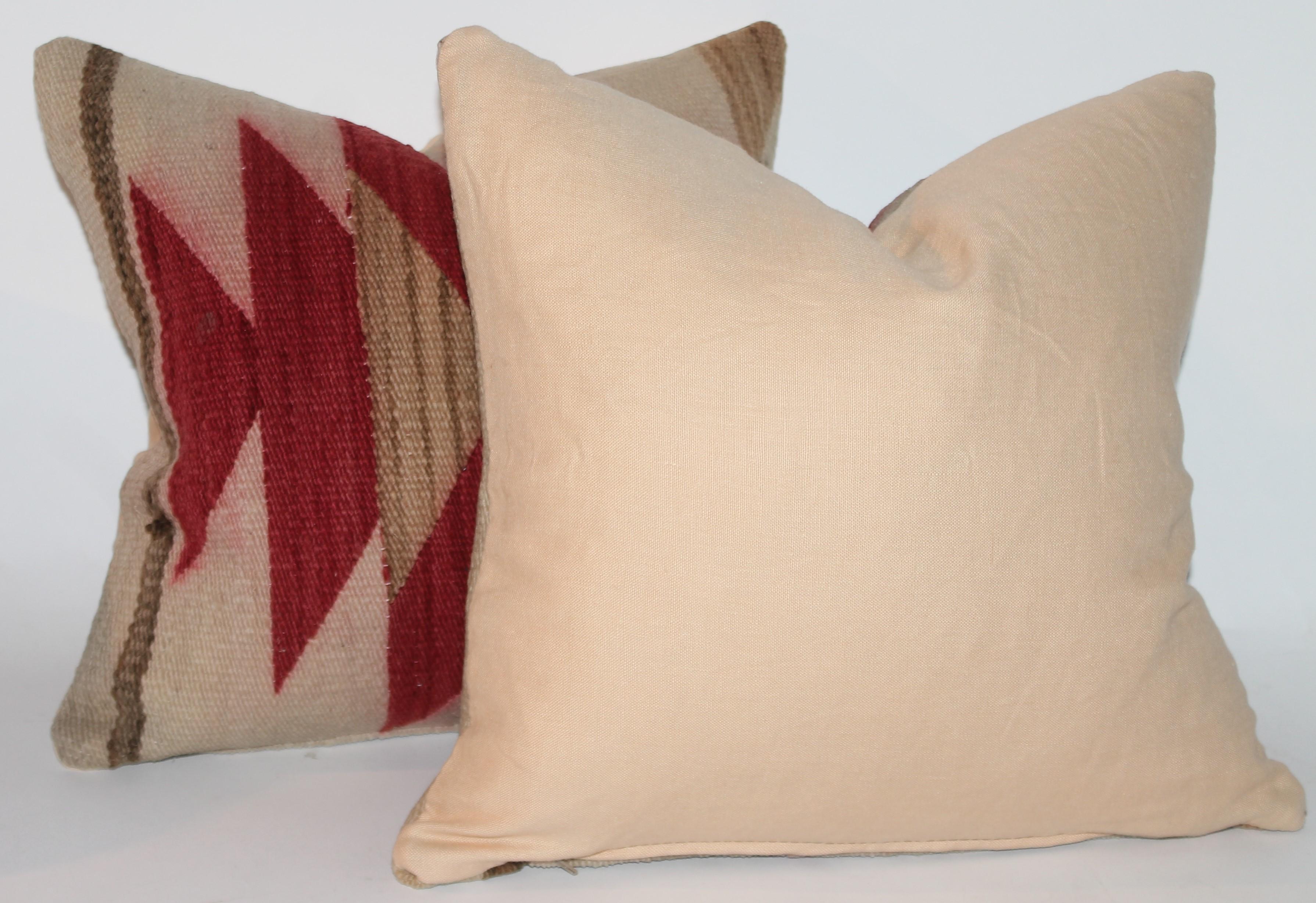 This pair of Navajo Indian weaving pillows are in good condition. The backings are cotton linen and down and feather fill.