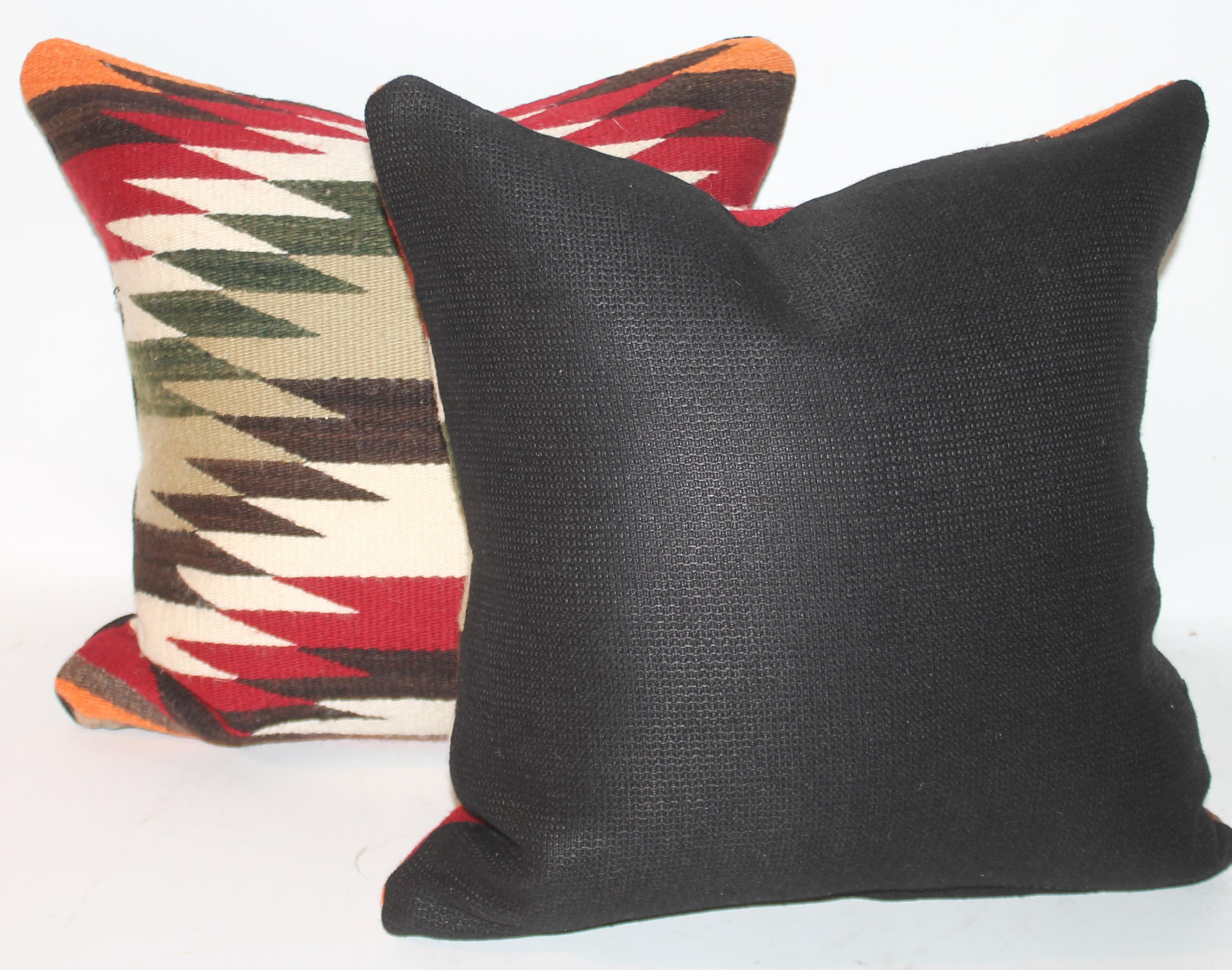 Cette paire de coussins géométriques en tissage indien Navajo est en excellent état. Ils sont en bon état avec un support en coton noir.