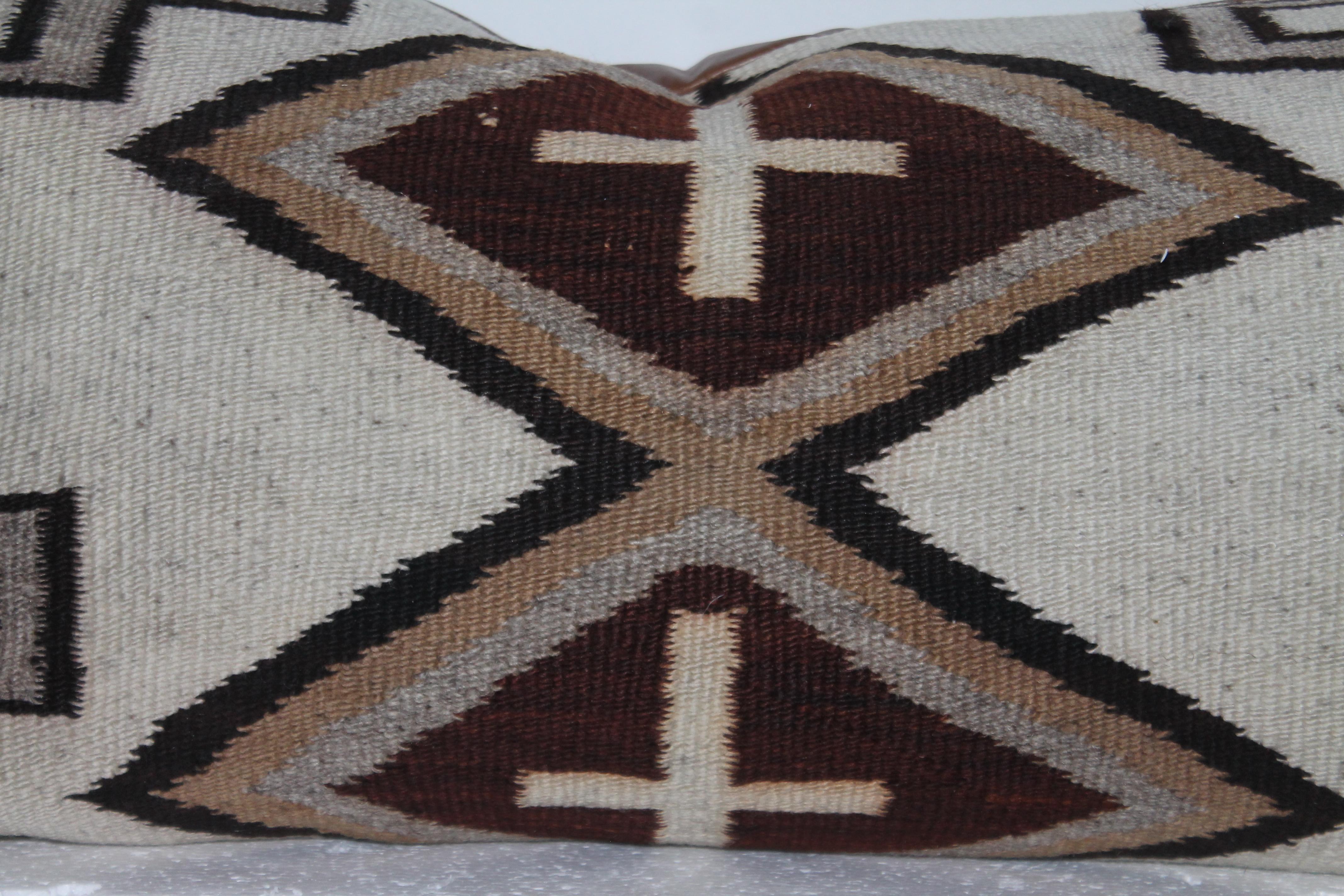This large Navajo Indian weaving bolster pillow has a leather backing and has crosses for a design pattern. The condition is very good.