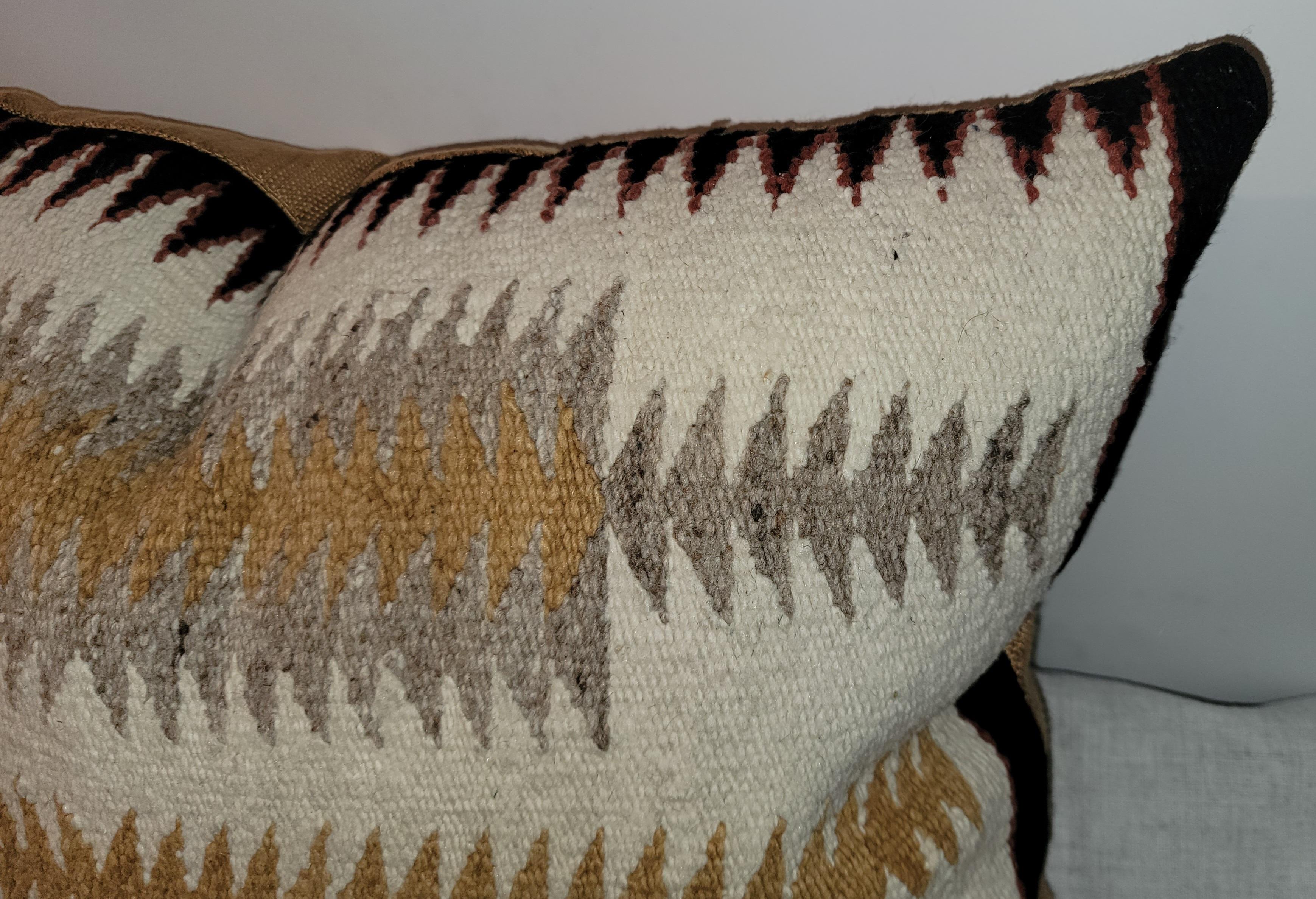 This American Navajo Indian weaving saddle blanket was made into a large bolster pillow. This amazing birds in flight pattern is fantastic.
The backing is in a country tan linen. The insert is down & feather fill.The border is a saw tooth border.