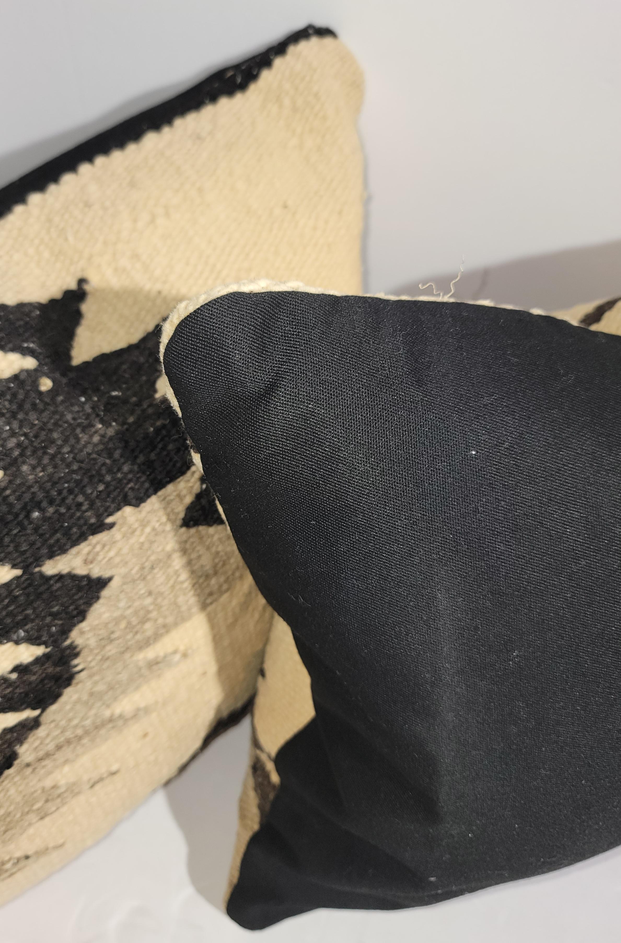 Almohadas de tejido indio navajo en buen estado y relleno de plumas y plumón. El reverso es de lino negro.