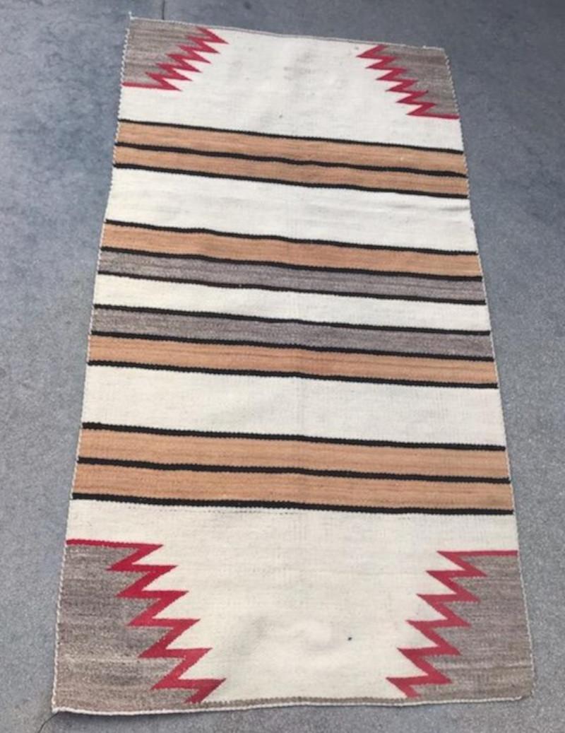 This fine striped Navajo Indian weaving is in good condition with zig zag ends. The weaving has a somewhat overall fade look to it.