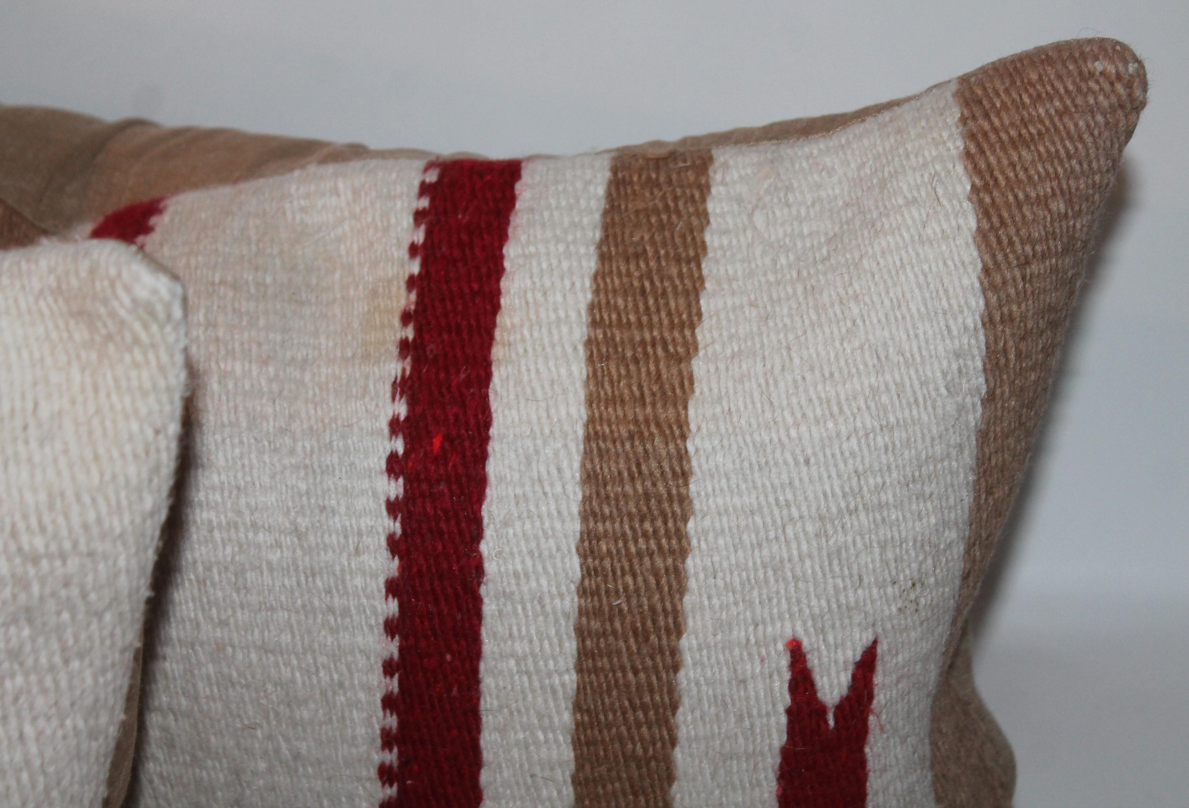 These Navajo Indian weaving saddle blanket bolster pillows are in good condition and have matching tan cotton linen backings. The inserts are down and feather fill. 

 