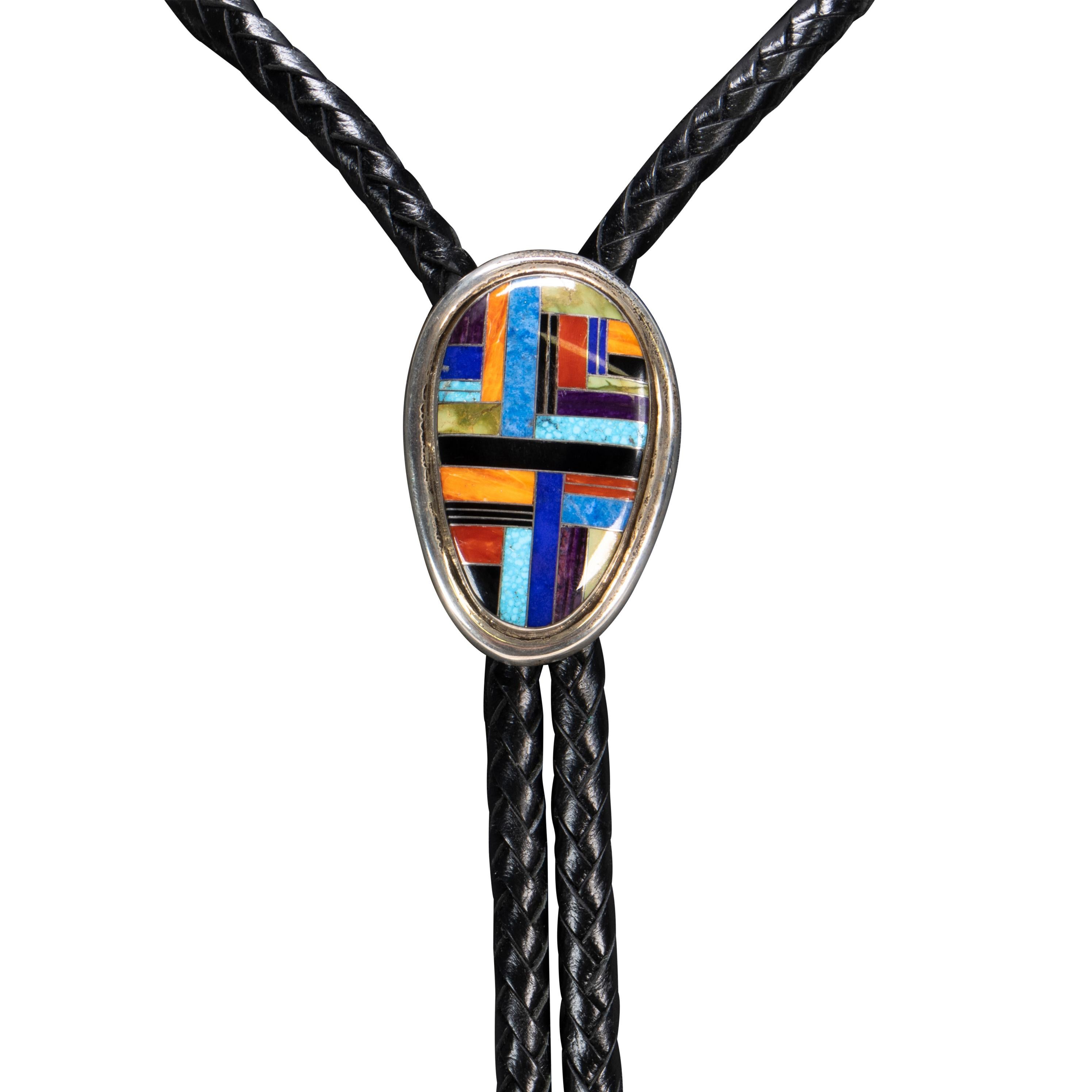 Navajo multi inlaid stone and sterling silver bolo tie by Navajo silversmith Frank Chee. Stones of turquoise, blue jean lapis, lapis, spiny oyster, onyx, agate and petrified wood set in sterling silver. Maker's mark 