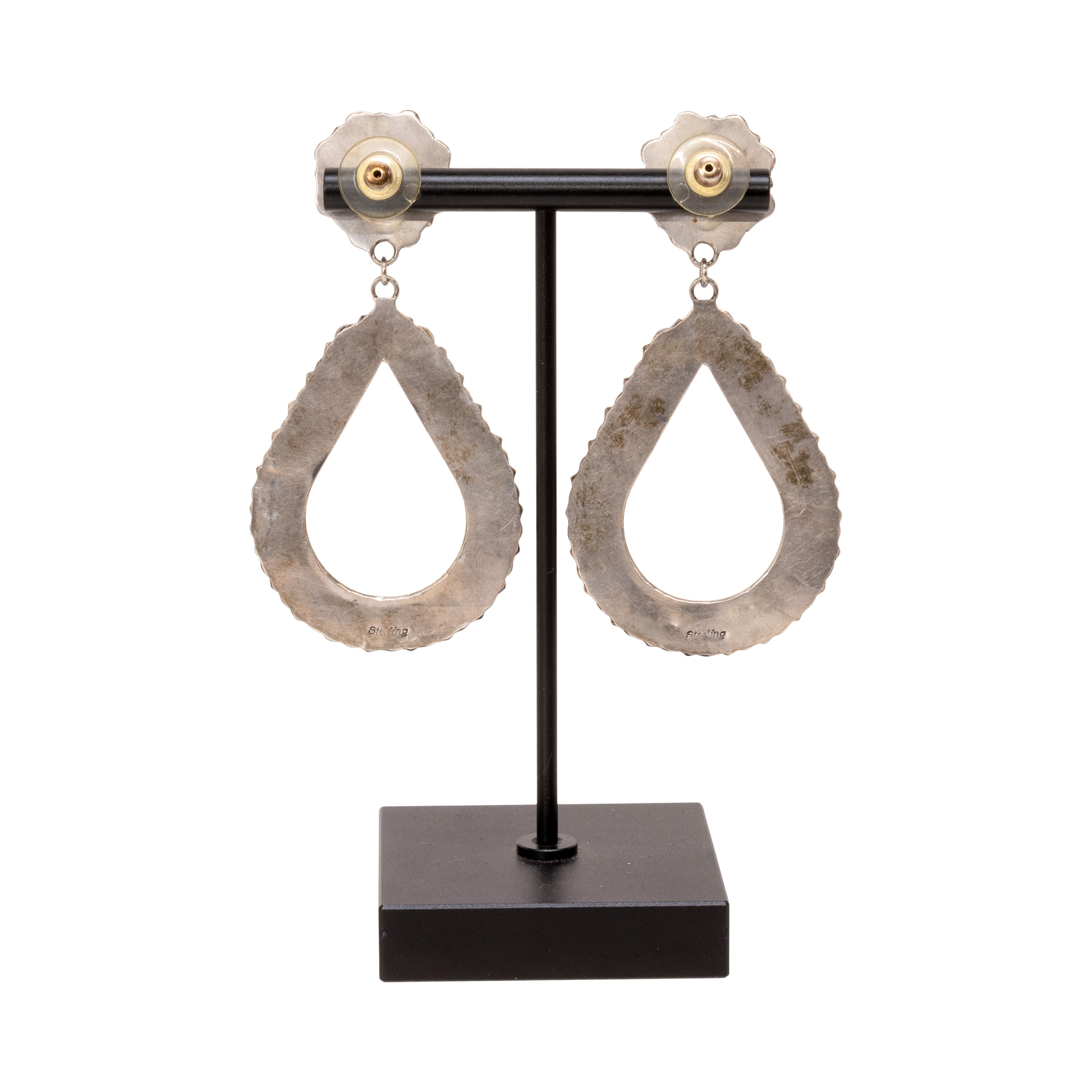 Boucles d'oreilles pendantes en argent sterling Navajo et Jett. Chaque boucle d'oreille comporte 33 pierres Jett d'un noir profond, chaque pierre étant sertie dans un chaton en dents de scie. La partie supérieure est ornée d'une composition florale