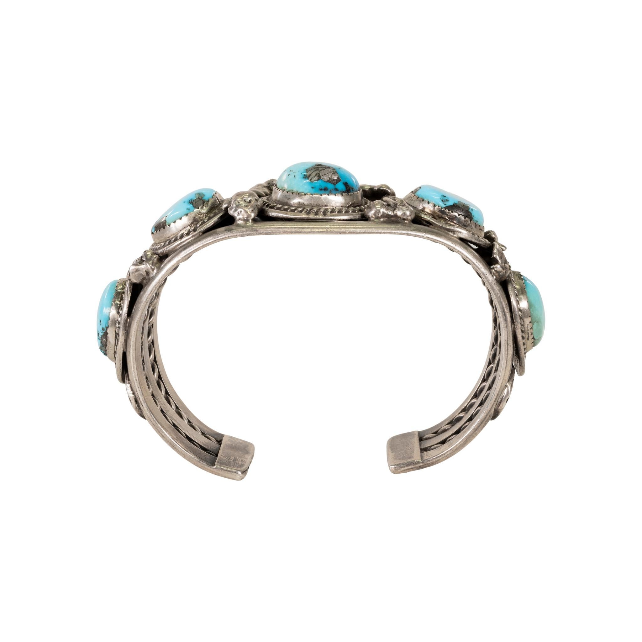 Bracelet en turquoise Navajo Kingman avec cinq pépites entourées d'une bordure en corde torsadée. La turquoise est une superbe couleur bleu clair d'excellente qualité. 

PÉRIODE : Après 1950
ORIGINE : Navajo, Sud-Ouest
TAILLE : 7