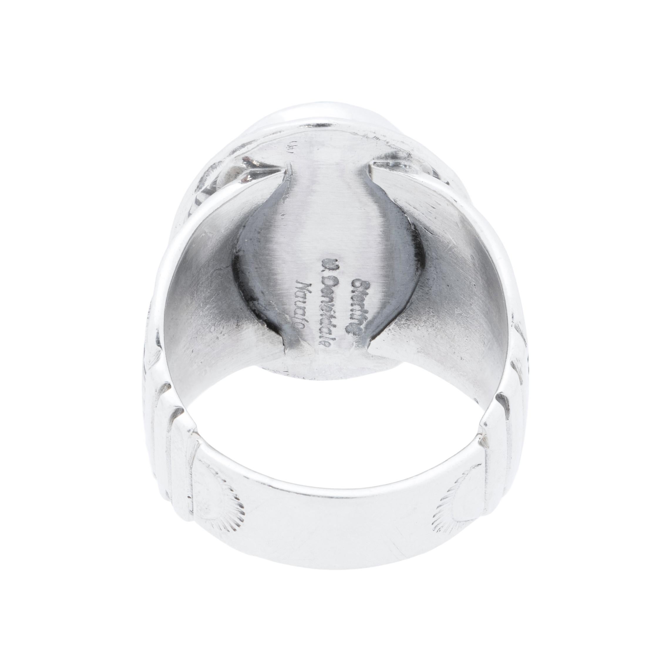 Anello Navajo in argento sterling e turchese Kingman. Pietra naturale e non trattata in cima a un classico bordo in corda ritorta con segni di taglio e palmette stampate a mano che attraversano la spessa fascia. Realizzato dall'argentiere navajo W.
