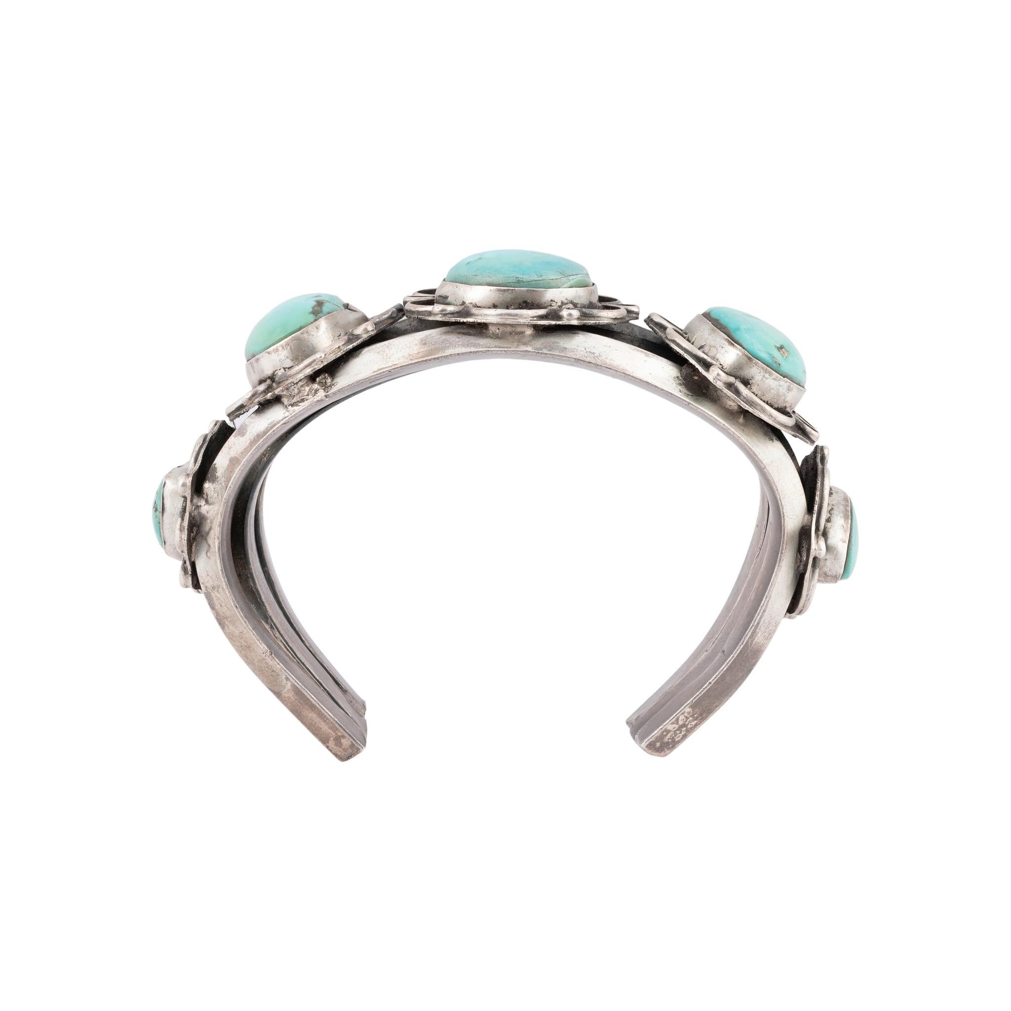 Bracelet manchette en turquoise Navajo Kingman et argent sterling. Cinq excellentes pierres serties dans des boîtes d'ombre festonnées sur trois anneaux coulés dans le sable et moulés ensemble avec des motifs de palmettes. Bracelet solide sans