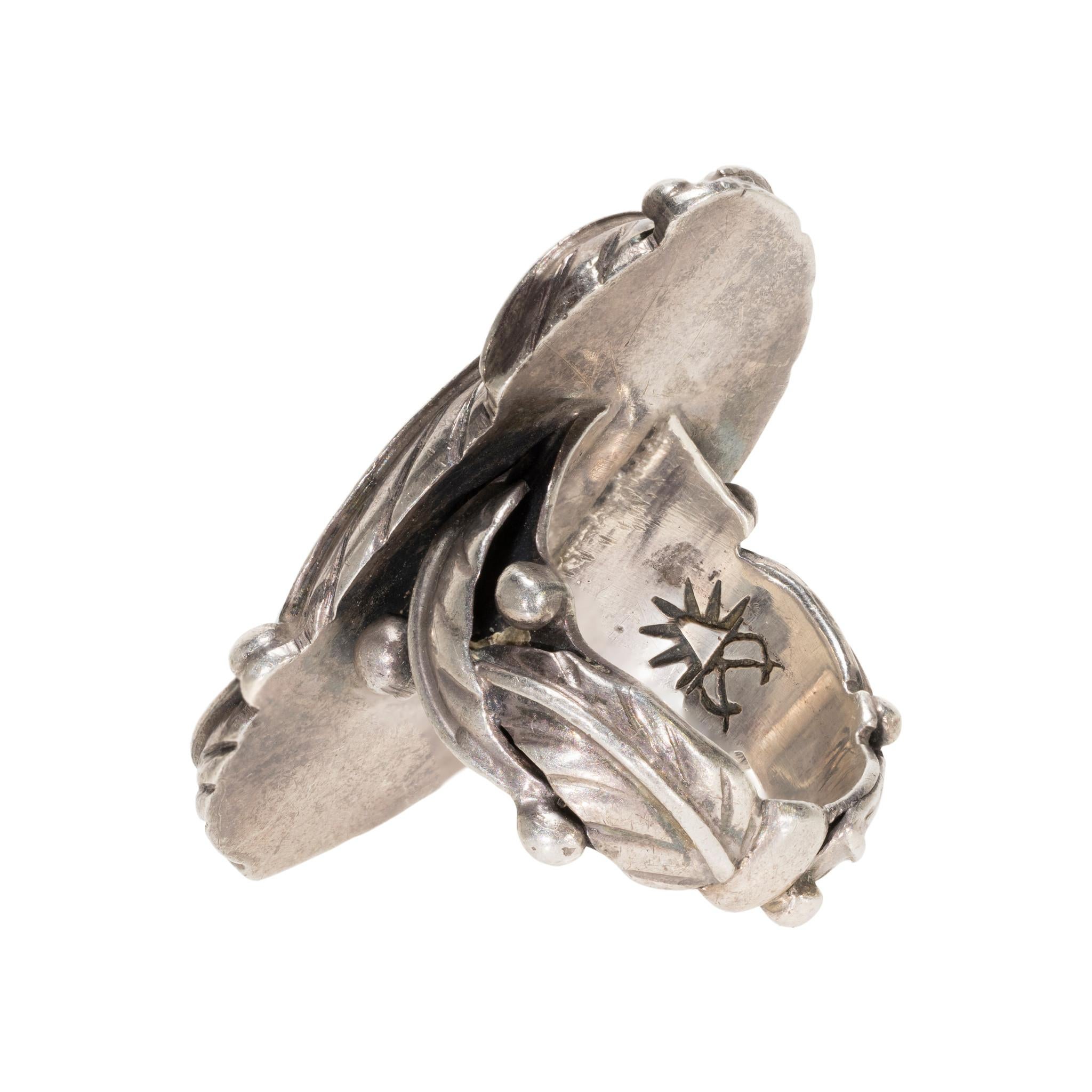 Navajo Kingman turquoise and sterling ring. Center stone surrounded by leaf design with leaves and beads all around band. Pictorial maker's mark on inside of band. Stone is a stunning deep blue with silver matrix. Exceptional statement piece, great