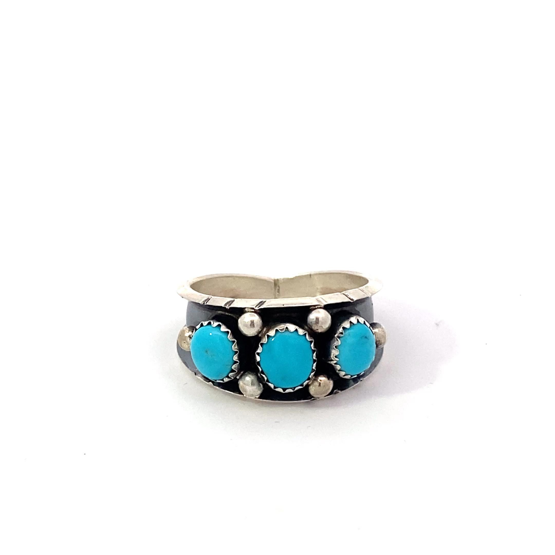 A striking ring crafted in sterling silver, featuring vibrant turquoise cabochons sourced from the renowned Kingman Mine in Arizona. Each stone showcases the unique blue-green hues and natural veining that make Kingman turquoise so iconic. The