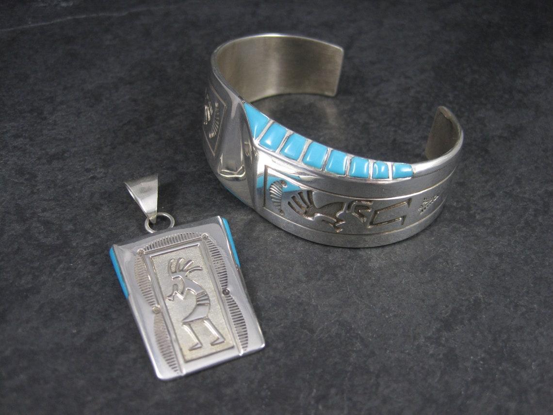 This gorgeous pendant and cuff bracelet jewelry set is sterling silver with natural sleeping beauty turquoise.

These pieces are the creation of Navajo silversmith Leonard Jim.

The pendant:
Measurements: 1 1/16 by 2 1/16 inches
Marks: Sterling,