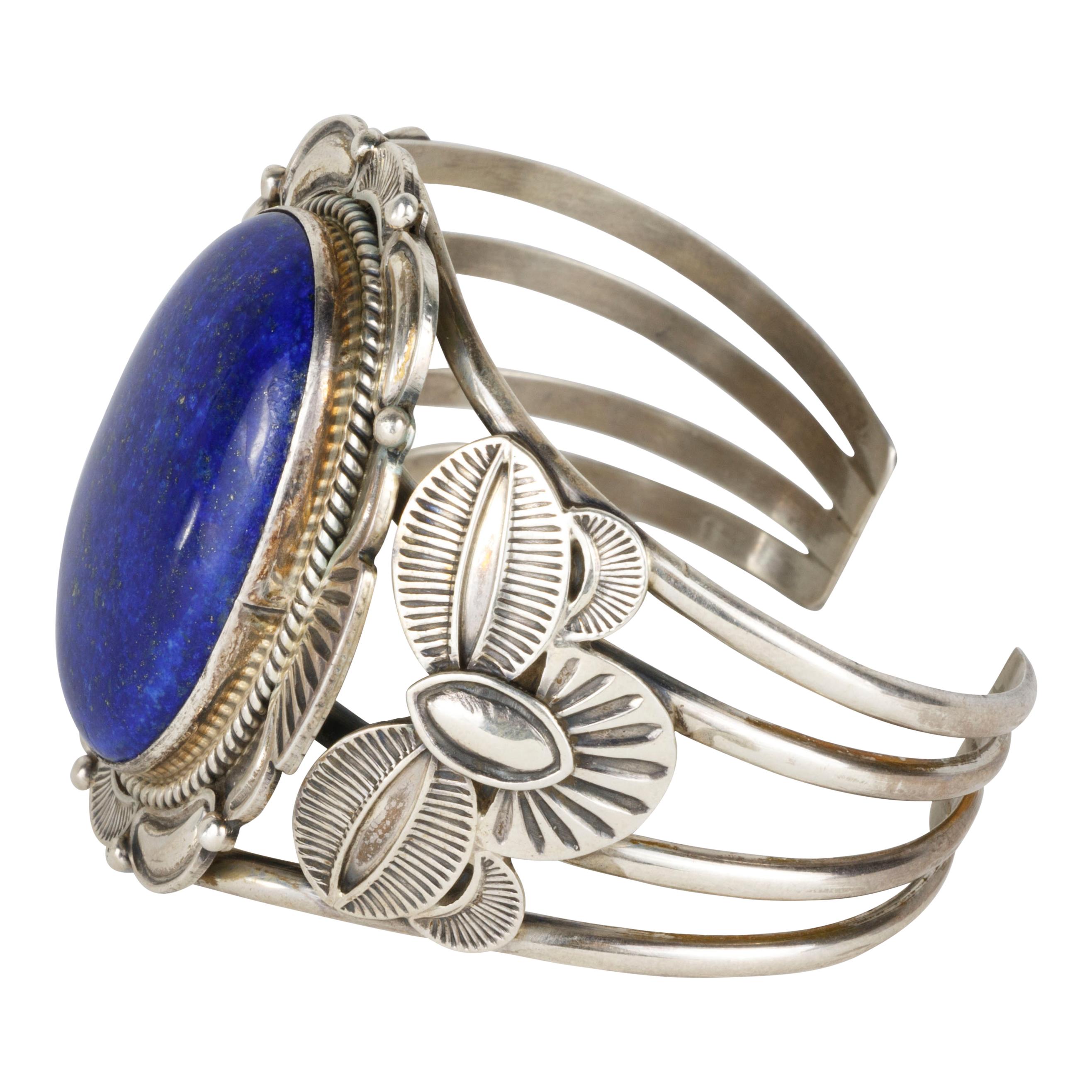 Beautiful Navajo lapis bracelet with silver leaf design and large lapis center stone. Maker marked M. Spencer. Marked sterling silver. Excellent silver work!

PERIOD: After 1950
ORIGIN: Navajo, Southwest
SIZE: 7