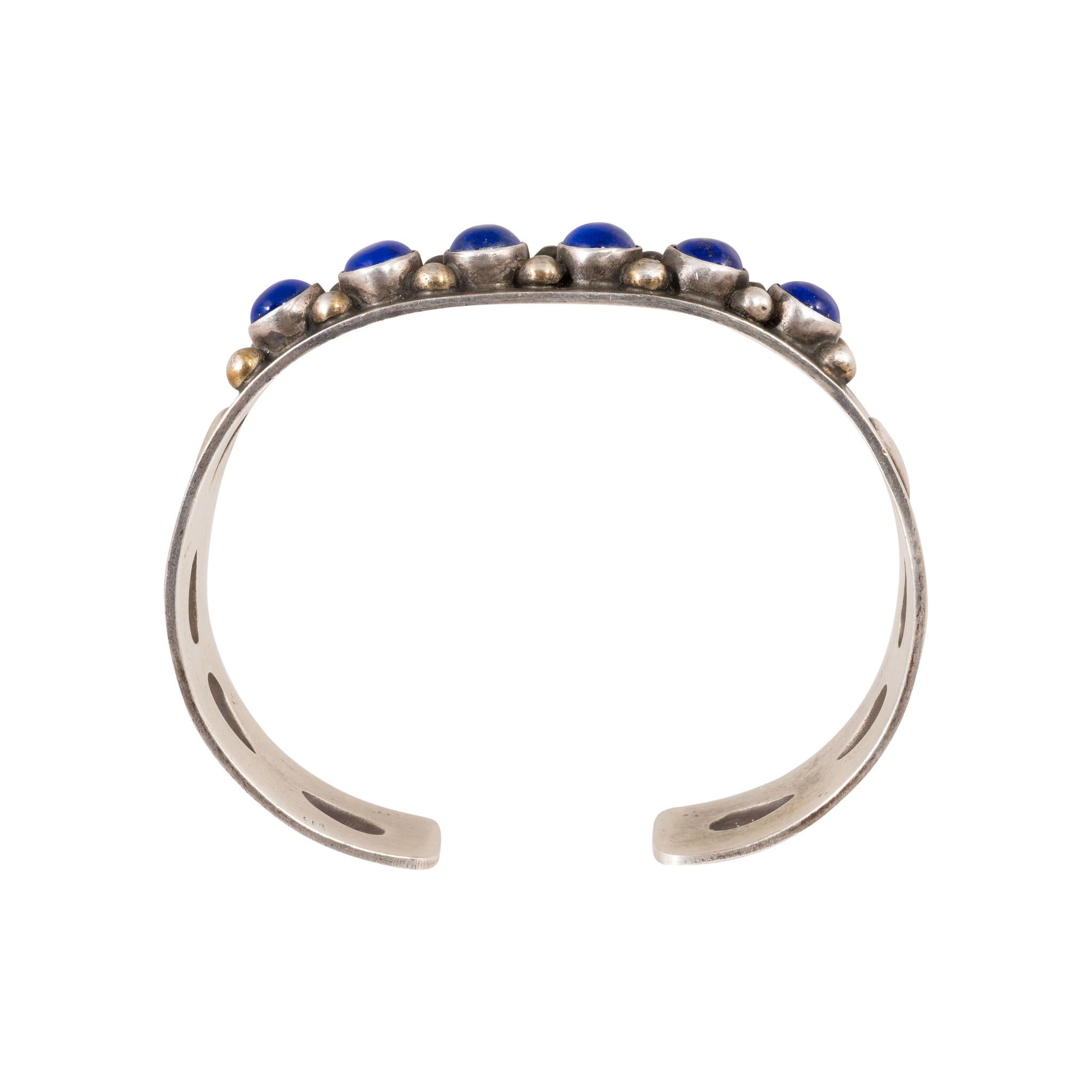Bracciale Navajo in lapis e argento sterling. Cinque ricche pietre blu incastonate in un castone con perline in argento. Incastonato in un bracciale sottile con disegni stampati sui lati. Il bracciale ha una certa flessibilità per aprirsi e