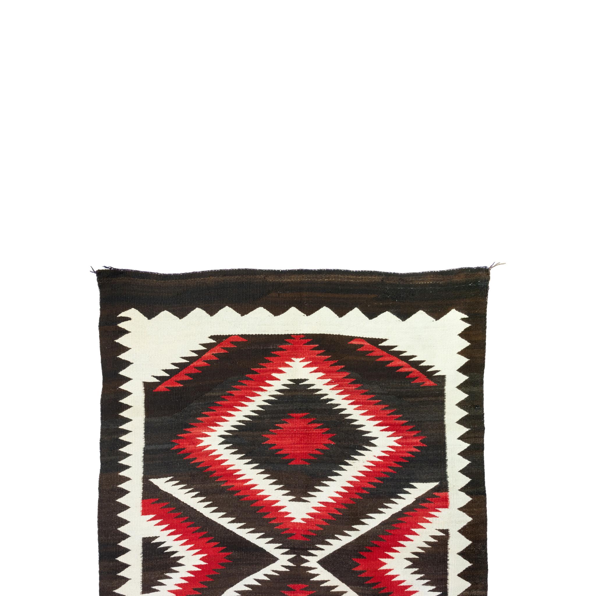 Tissage Navajo avec un motif d'éblouissement négatif. Fabriqué en laine mérinos douce. 

Origine : Navajo, Sud-Ouest
Période : vers 1920
Taille : 4'6