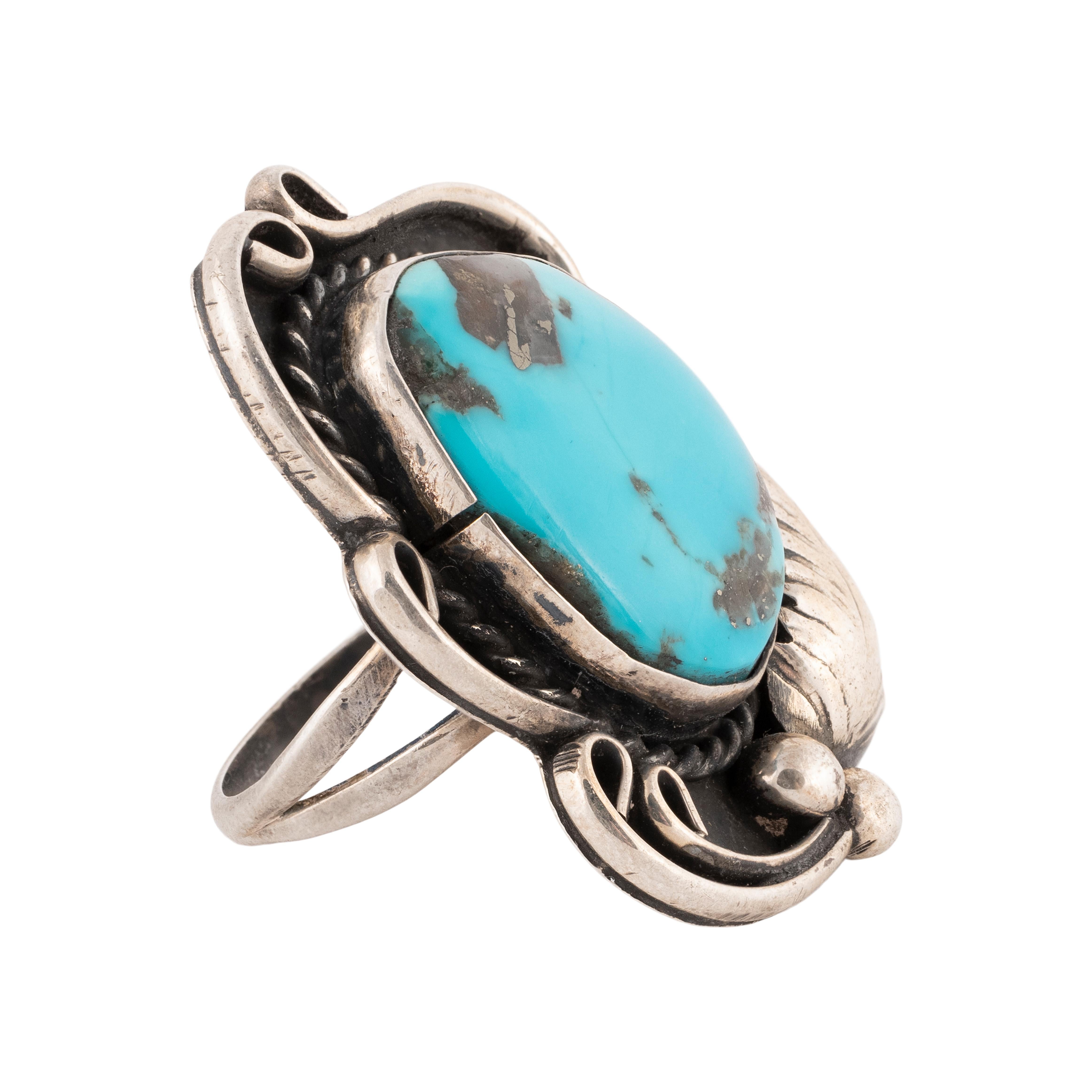 Navajo Morenci turquoise and sterling ring. Large stone set in shadow box design with classic twisted rope and leaf border.

PERIOD: After 1950

ORIGIN: Navajo, Southwest

SIZE: Size 8, Face 1.5