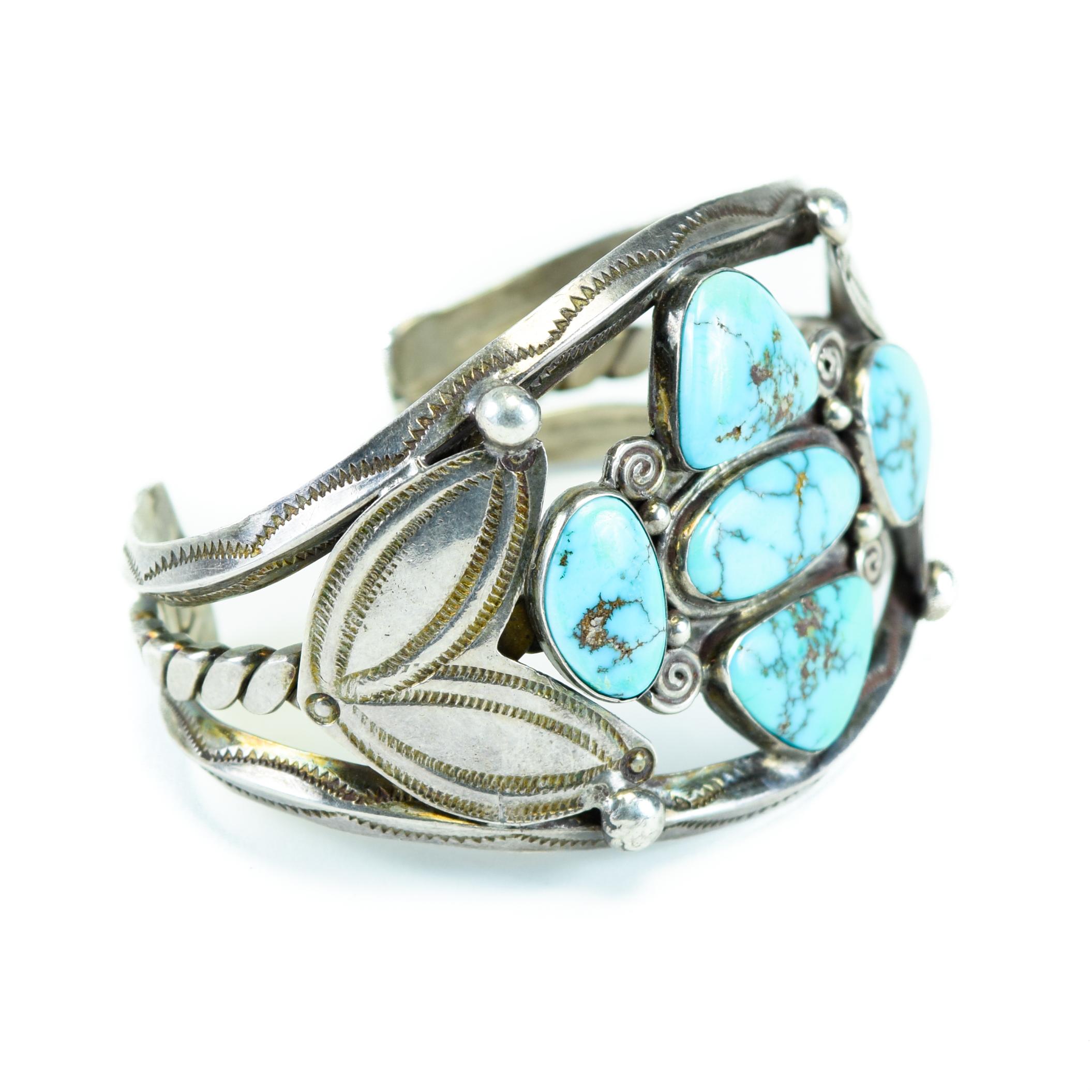 Exceptional Morenci turquoise cuff bracelet. Five matching stones, with double hand-stamped leaf design on each side.

PERIOD: 1950s
ORIGIN: Navajo, Southwest
SIZE: 2