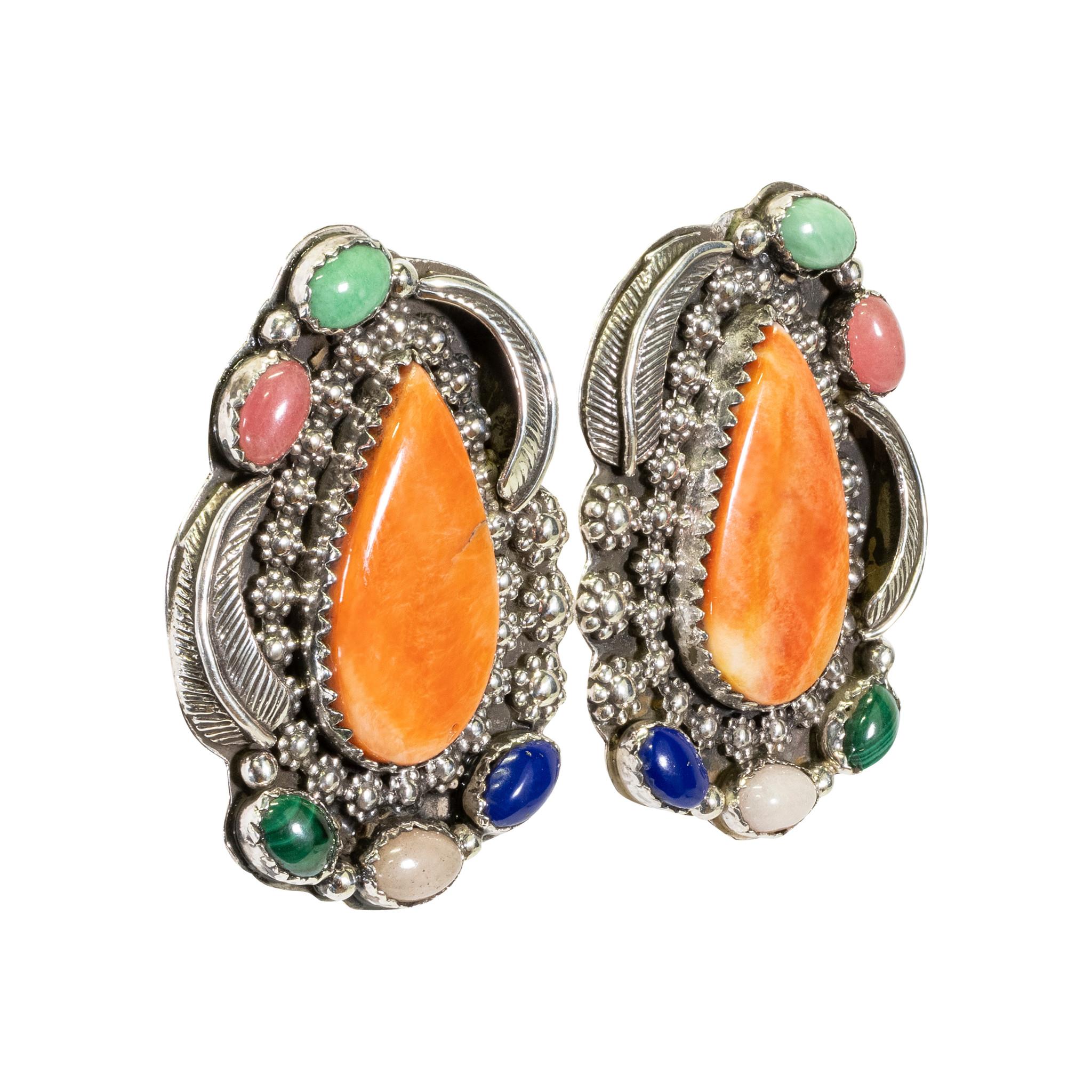 Orecchini a goccia in argento sterling e pietre multiple Navajo con chiusura a perno. Pietra centrale di ostrica spinosa tagliata a goccia in un castone a dente di sega, circondata da perline decorative floreali in sterling. Il bordo esterno è