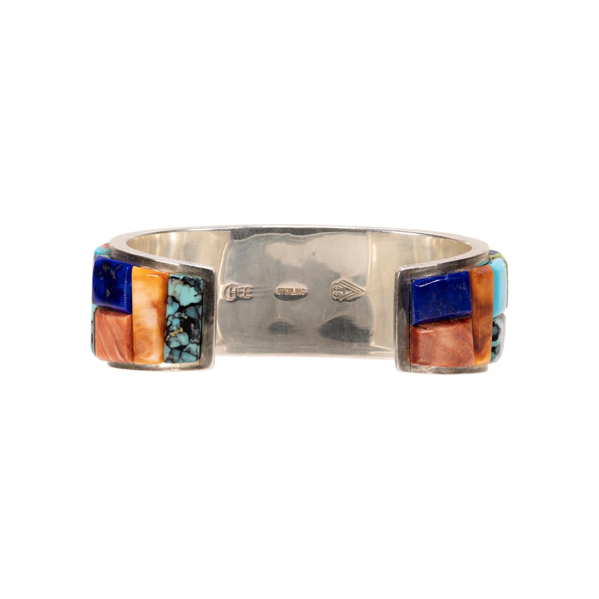 Brazalete navajo de plata de ley y piedras múltiples, obra del orfebre navajo Mark Chee. Piedras superpuestas de ostra espinosa, turquesa verde y azul, lapislázuli y ónice. Estampado 