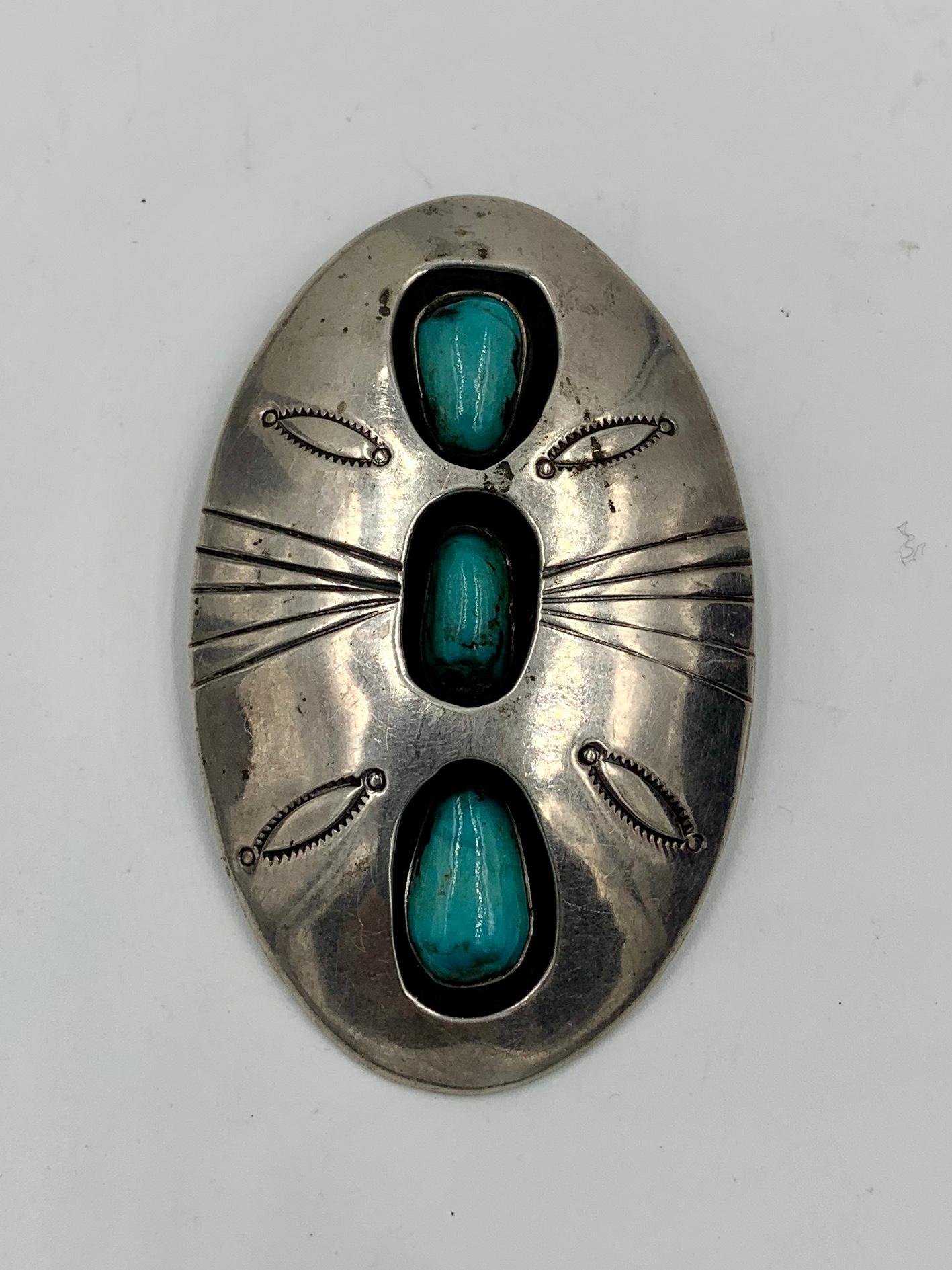 Uno splendido ciondolo antico in turchese Navajo dei nativi americani con bellissimi disegni stampati a mano in argento sterling.  Il ciondolo è di grandi dimensioni: 2,3/4 pollici di altezza e 1,3/4 pollici di larghezza.  Le tre pietre di turchese