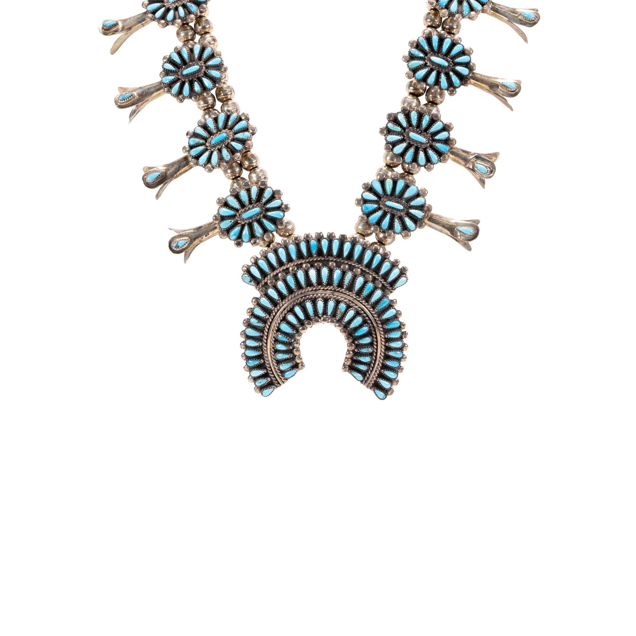 Navajo sterling silver and Sleeping Beauty turquoise squash blossom set. Set having squash blossom, ring, and matching earrings. Stunning needlepoint floral design, stones having light color with some matrix. Set made by Navajo artisan Francis