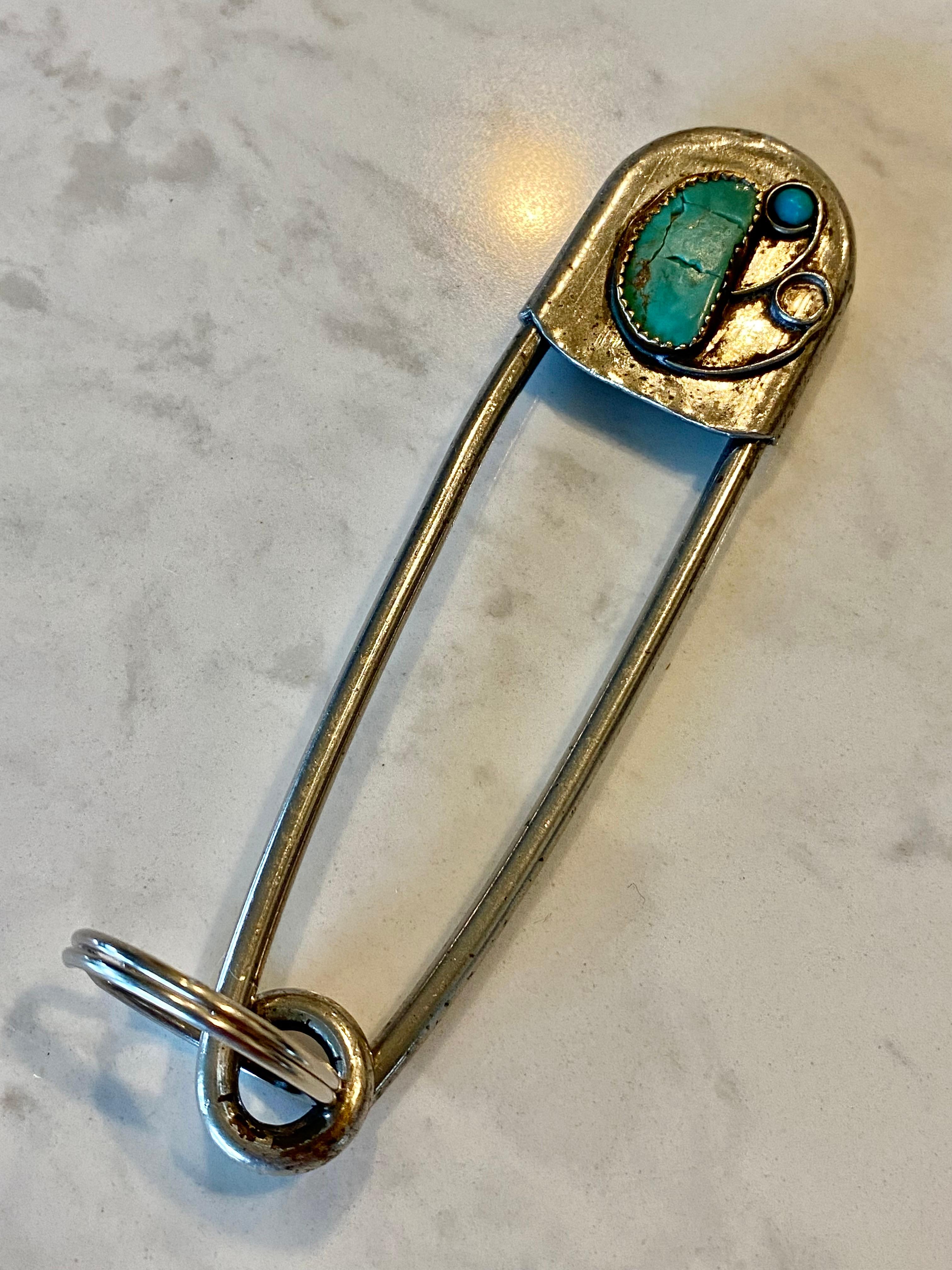 Llavero firmado Risdon, de época Navajo Old Pawn, con piedras de turquesa engastadas a mano que adornan un imperdible extragrande de plata de ley maciza. Esta pieza está firmada en el reverso con 