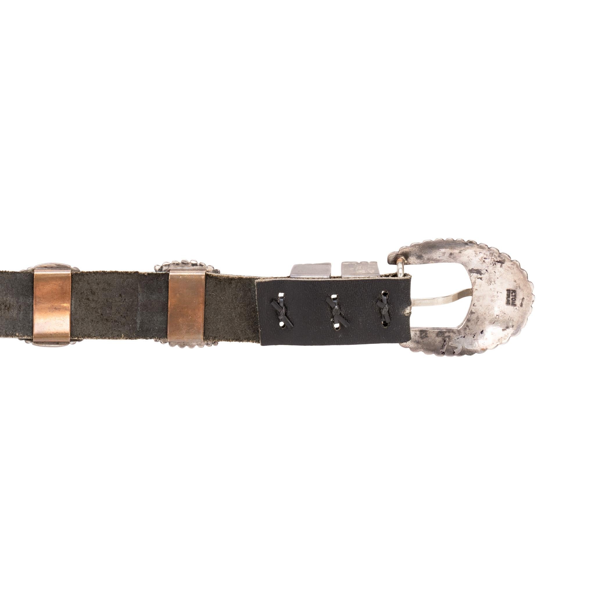 Navajo-Gürtel mit Concho aus Sterlingsilber von R. Tom. Insgesamt siebzehn Conchos mit abwechselnden Oval- und Schmetterlingsformen. Handgestempelte traditionelle Designs mit Diamant in der Mitte, befestigt an einem schwarzen Ledergürtel mit einer
