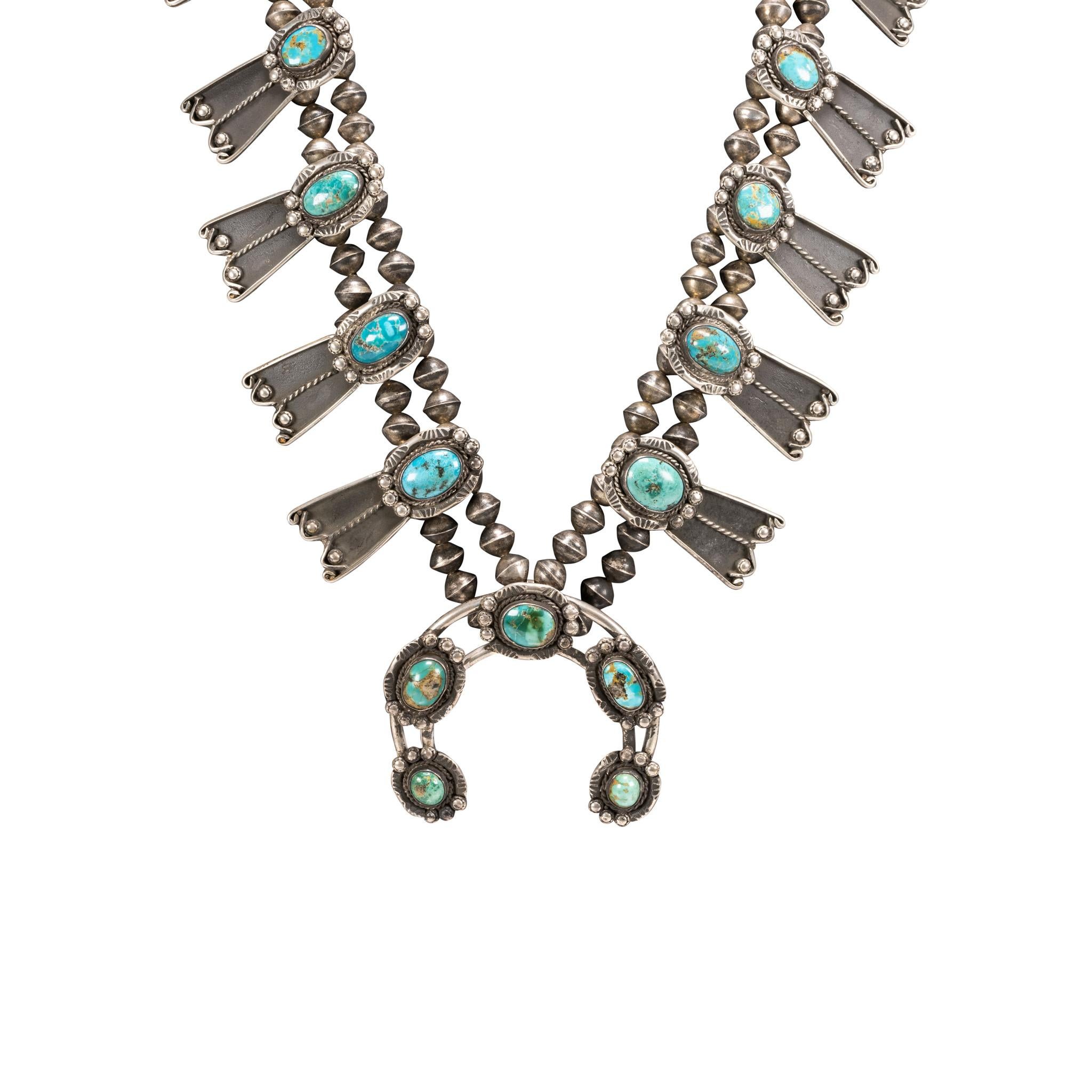 Navajo squash blossom necklace. Double strand necklace has ten stones in butterfly shadowbox setting with simple naja.The turquoise is from the Red Mountain mine in Nevada. Stones range from a light blue to dark green color with brown and gold