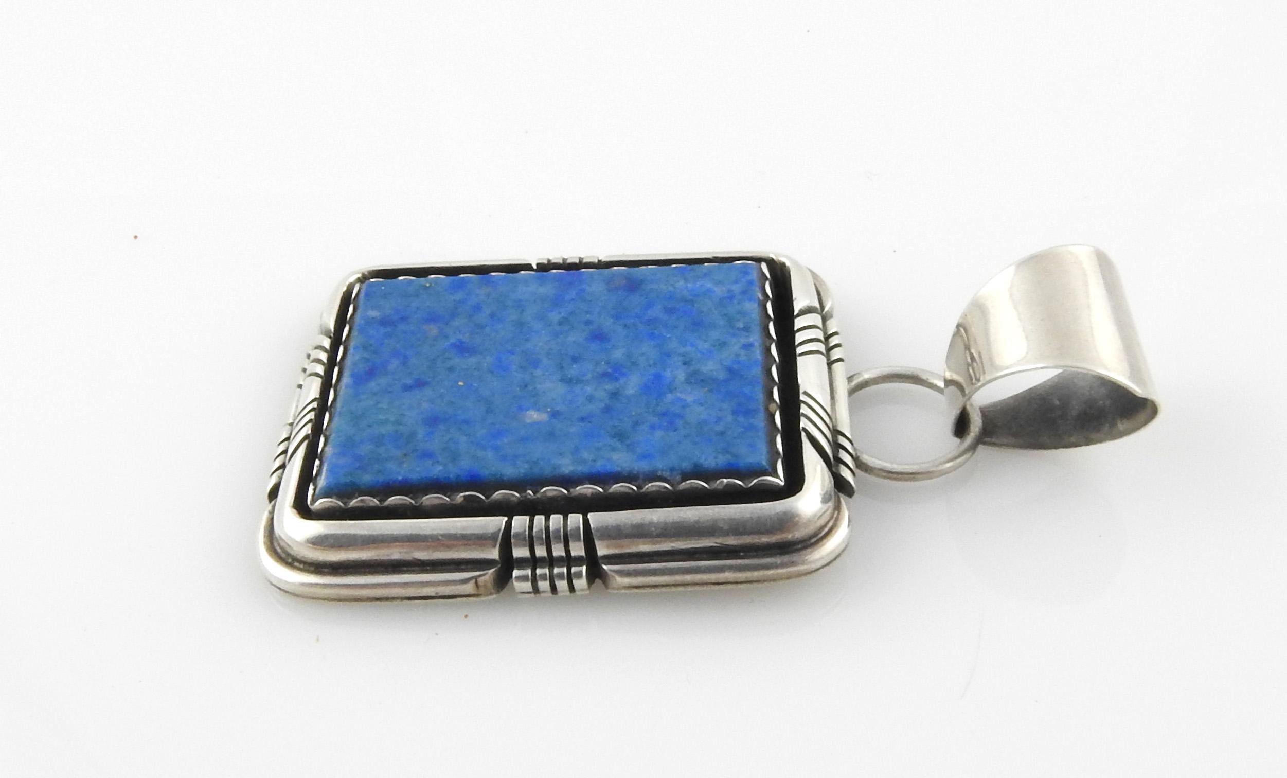 Navajo Robert and Noreen Kelly sterling silver lapis lazuli pendant.

Marked: ROBERT NOREEN KELLY 925 with feather hallmark.

Measures: 1 9/16